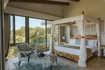 a bedroom with a canopy bed and a chaise longue