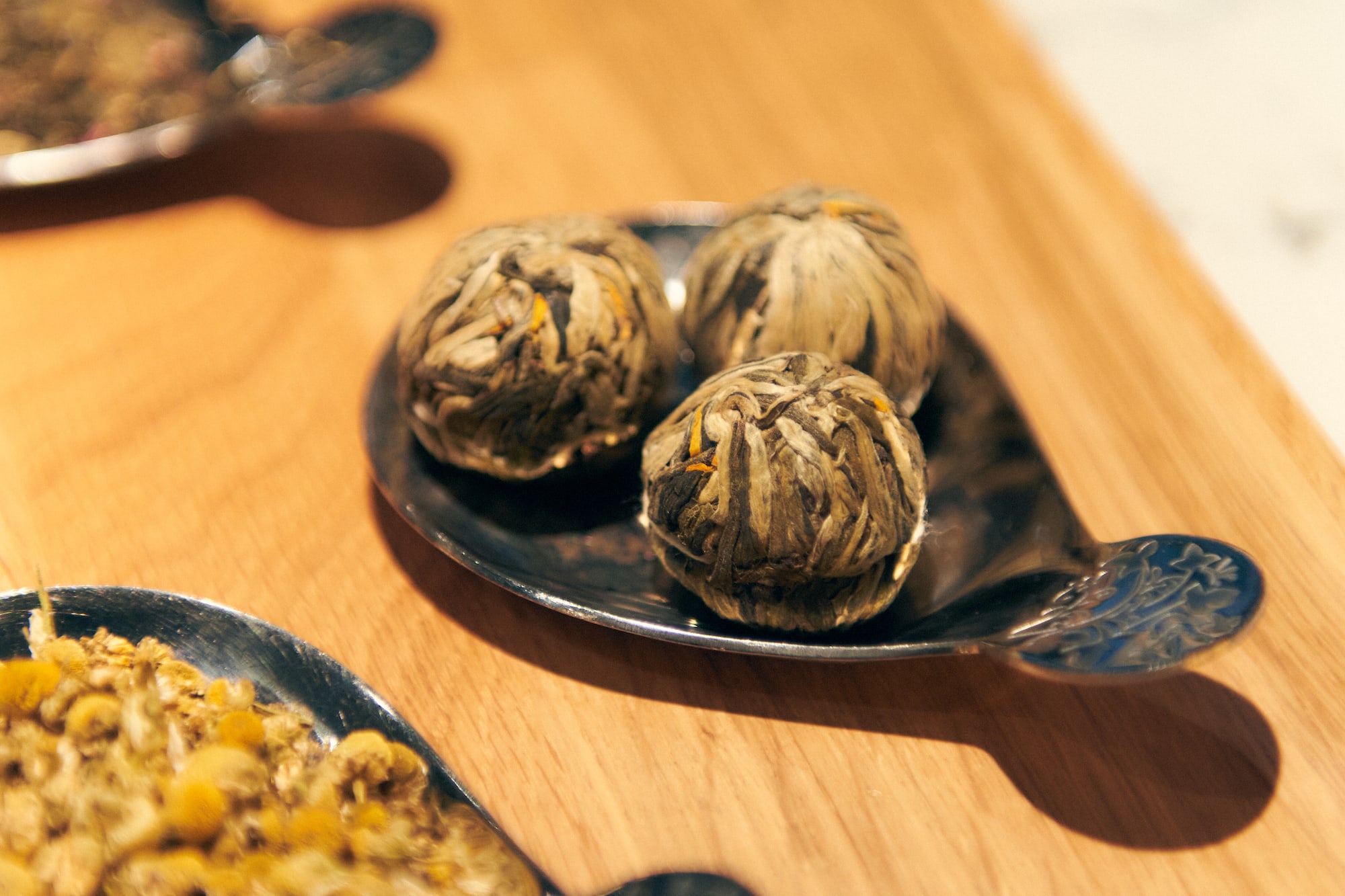 a group of silver spoons with herbs on them