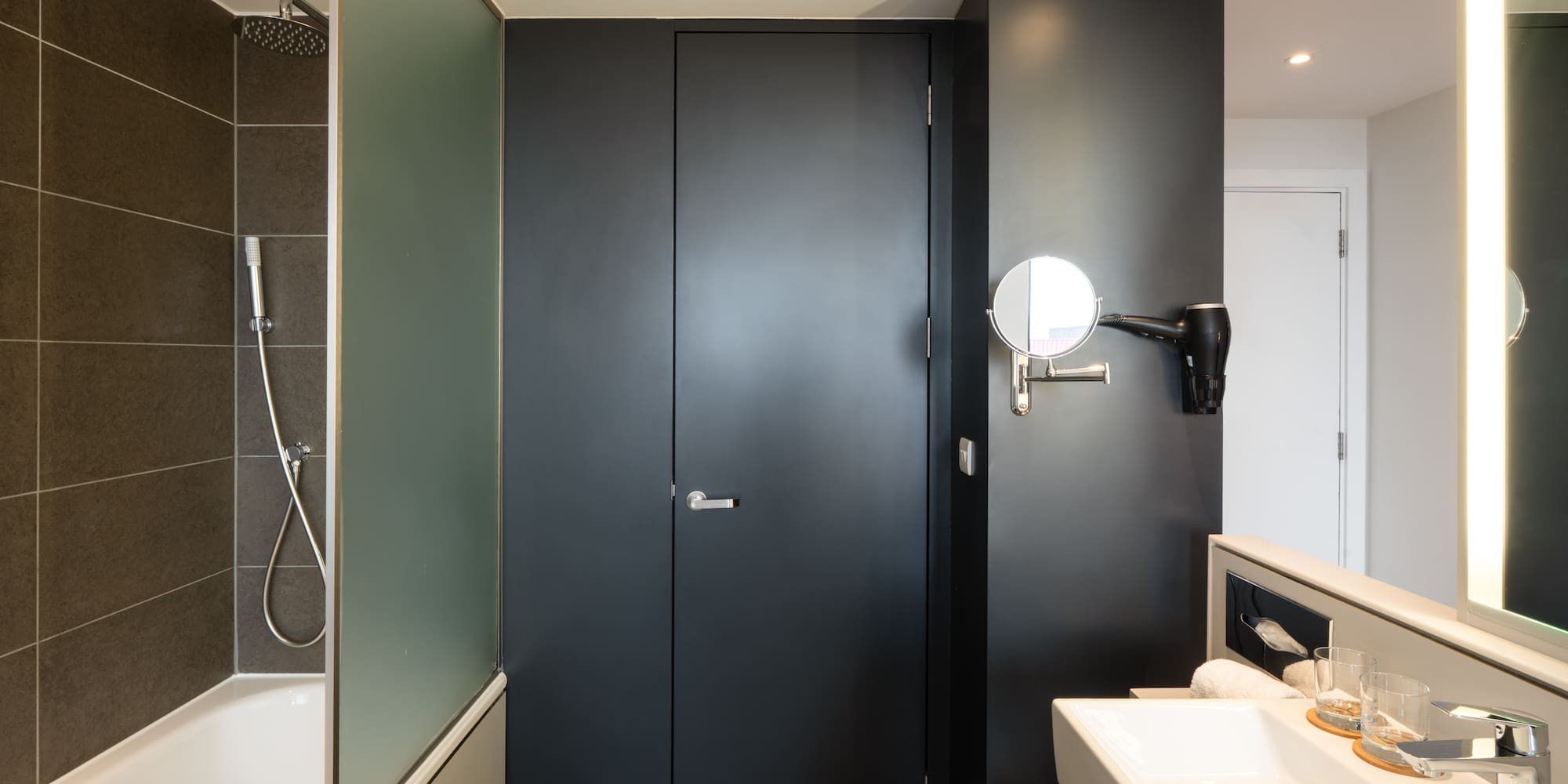 a bathroom with a black door and a sink