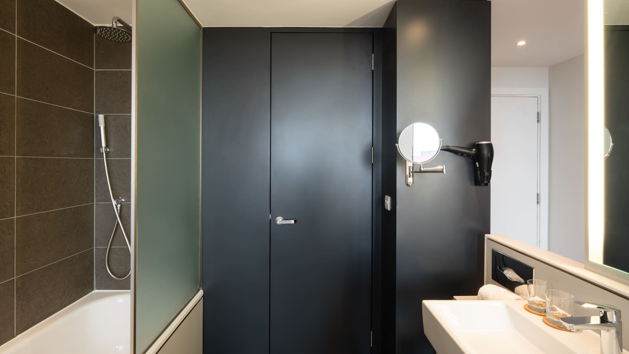 a bathroom with a black door and a sink