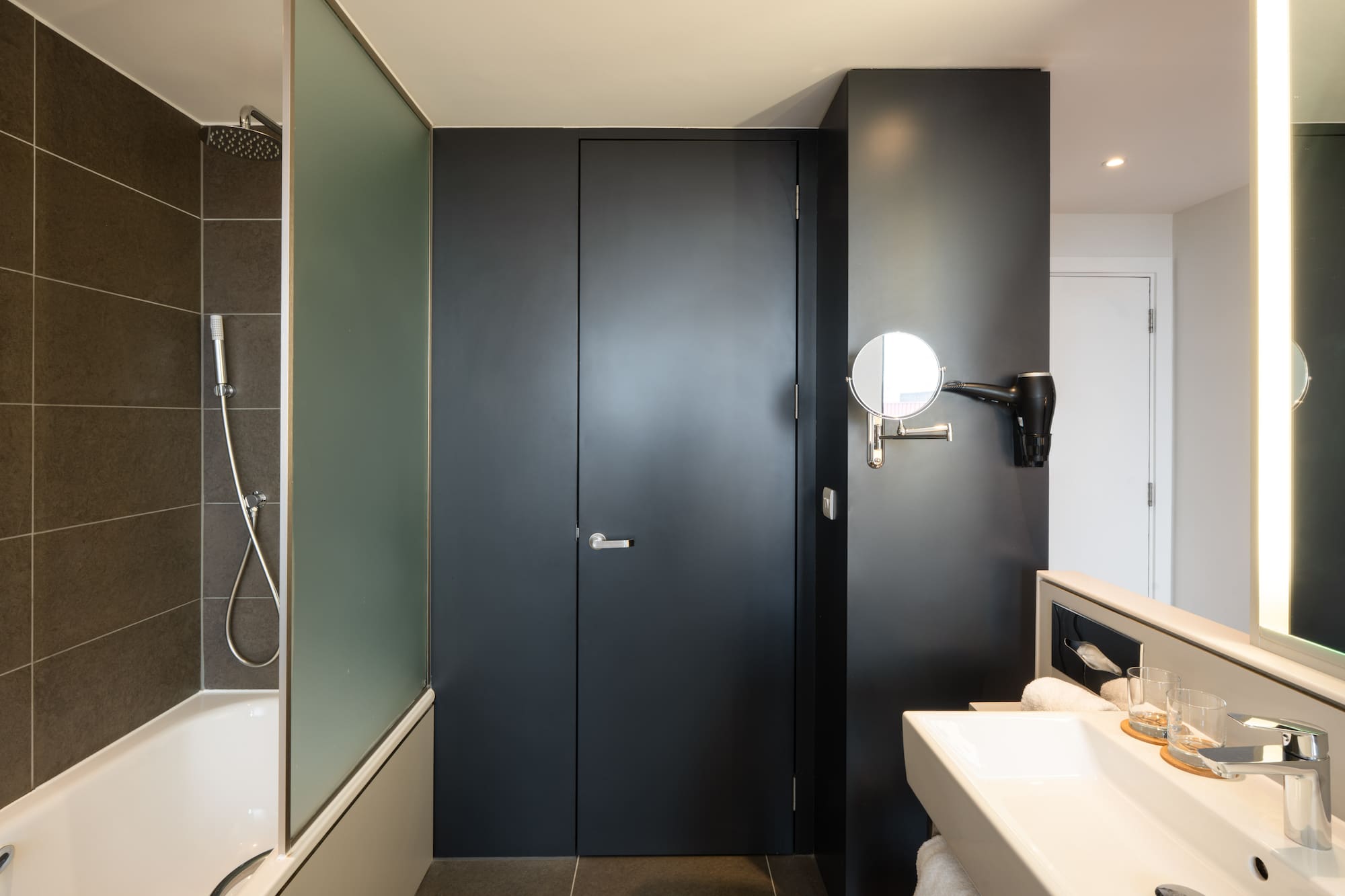 a bathroom with a black door and a sink