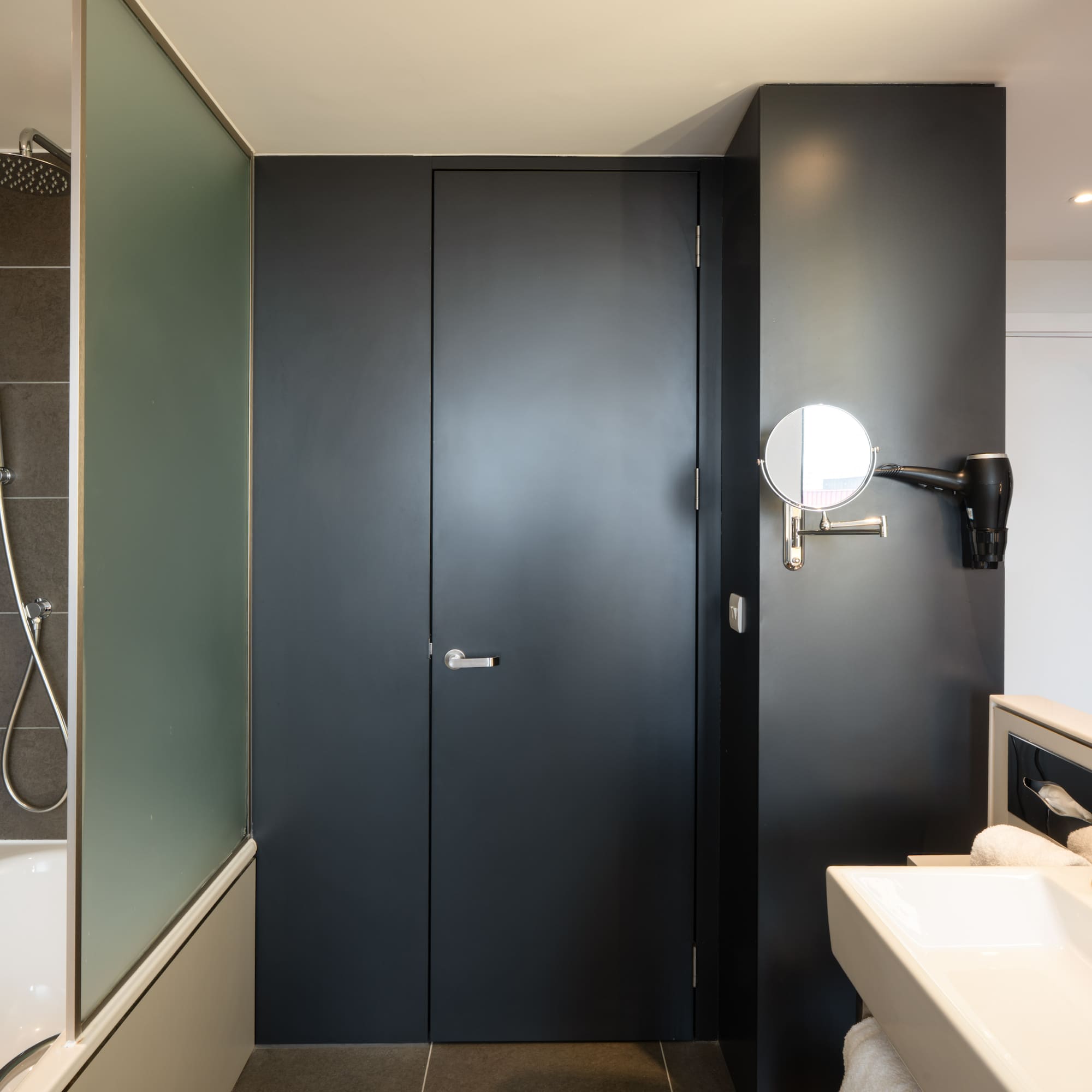 a bathroom with a black door and a sink