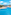 Resort swimming pool with ocean view, sunbeds, and blue sky.