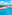 Resort swimming pool overlooking the ocean with sun loungers and blue sky.