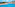 Resort swimming pool with ocean view, sunbeds, and blue sky.