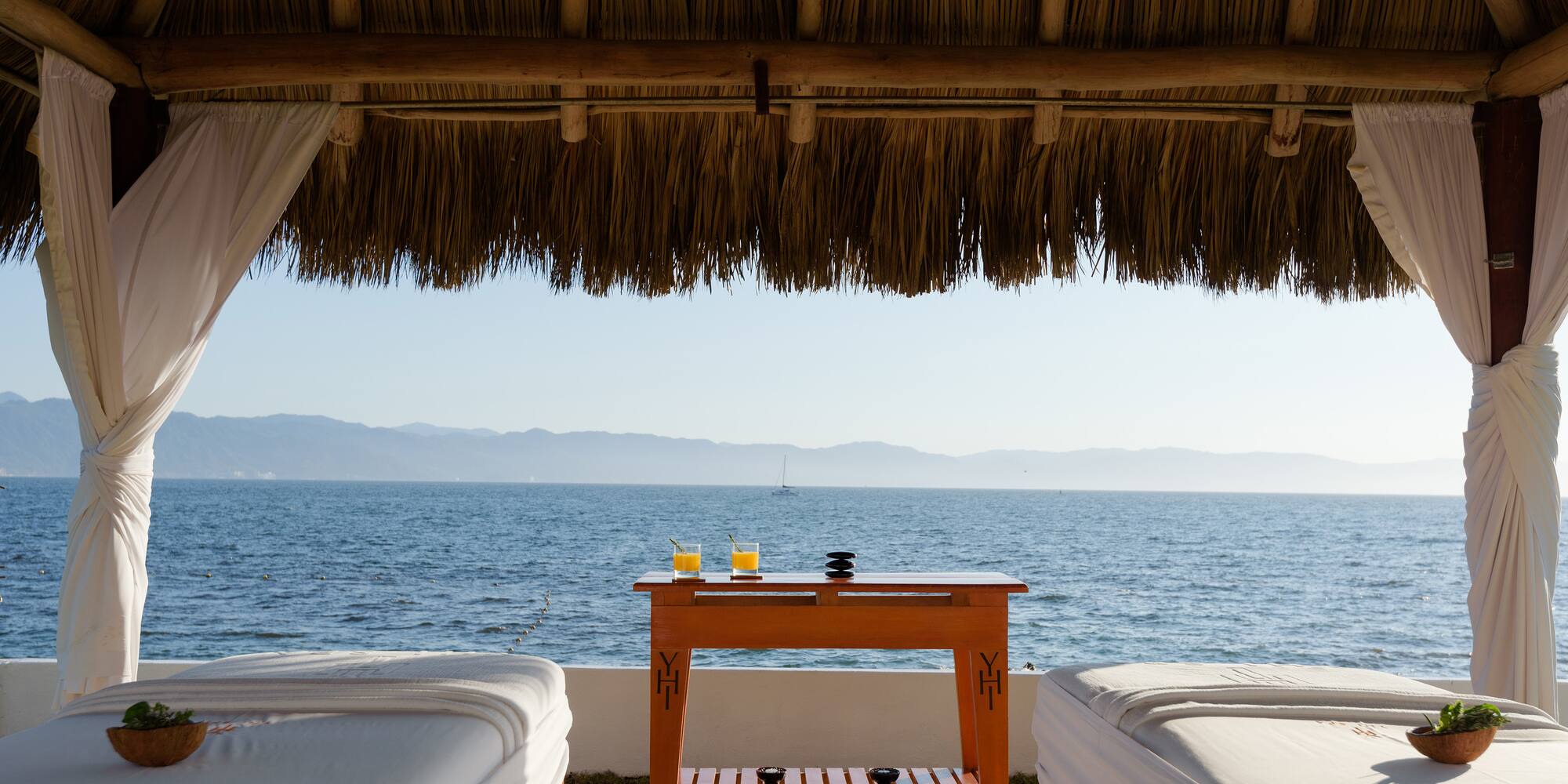 a table with drinks on it by a beach