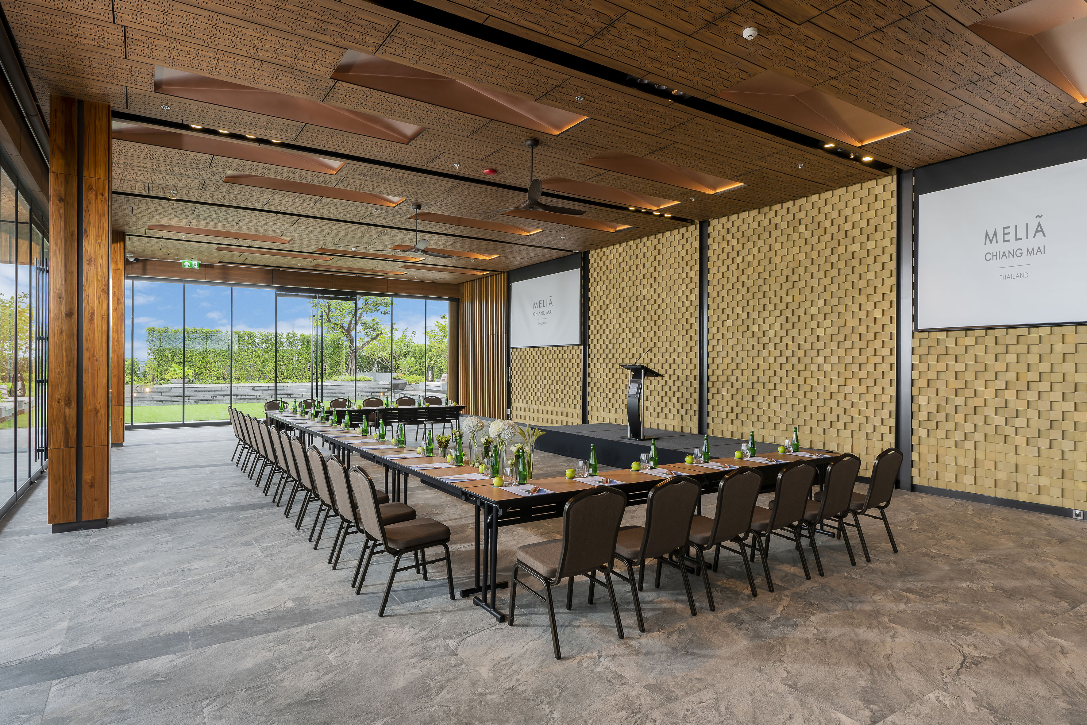 Meliá Chiang Mai conference room, U-shaped table, podium, screen, garden view.