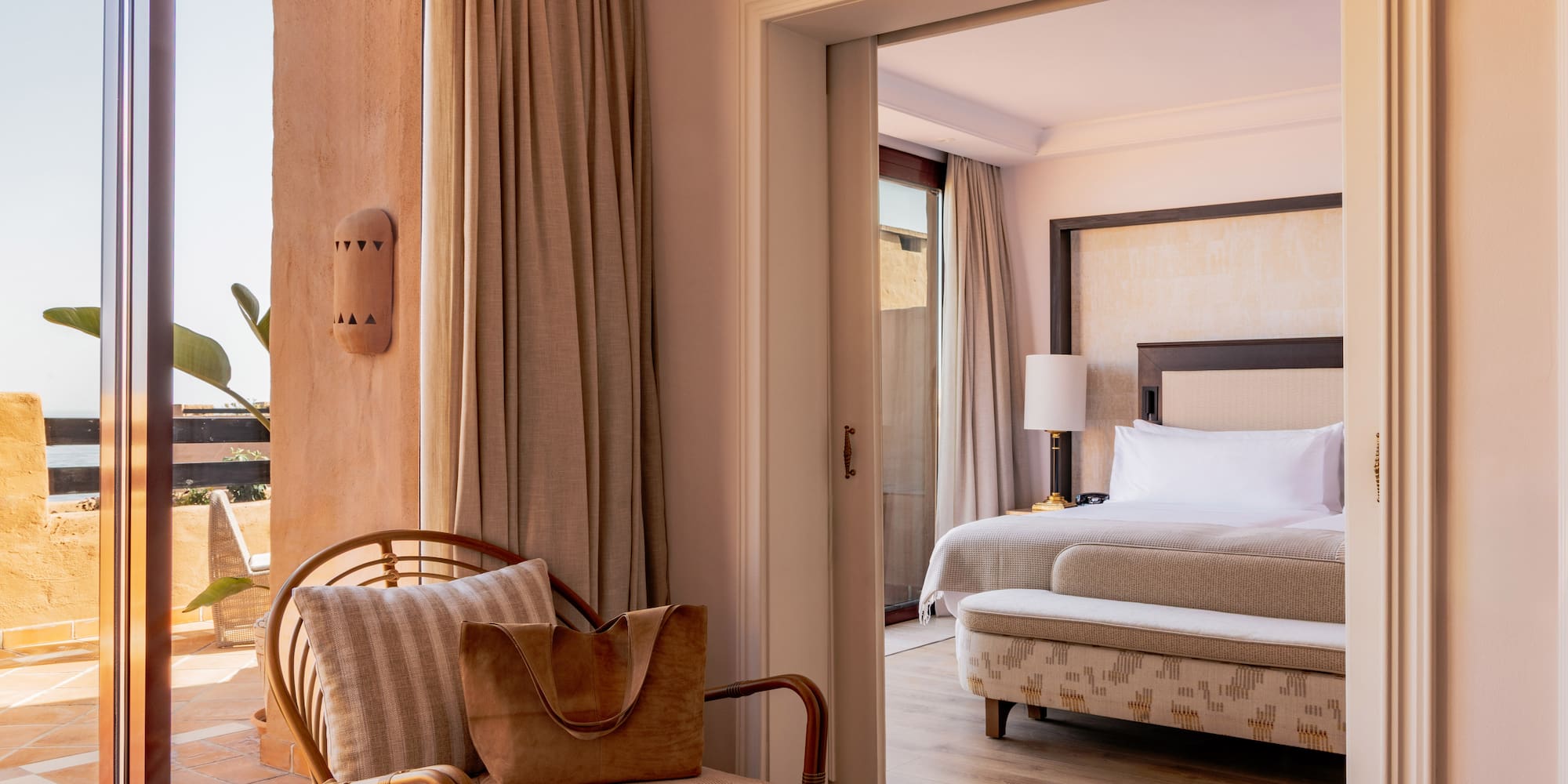 Elegant resort suite with private terrace access and spacious bedroom.