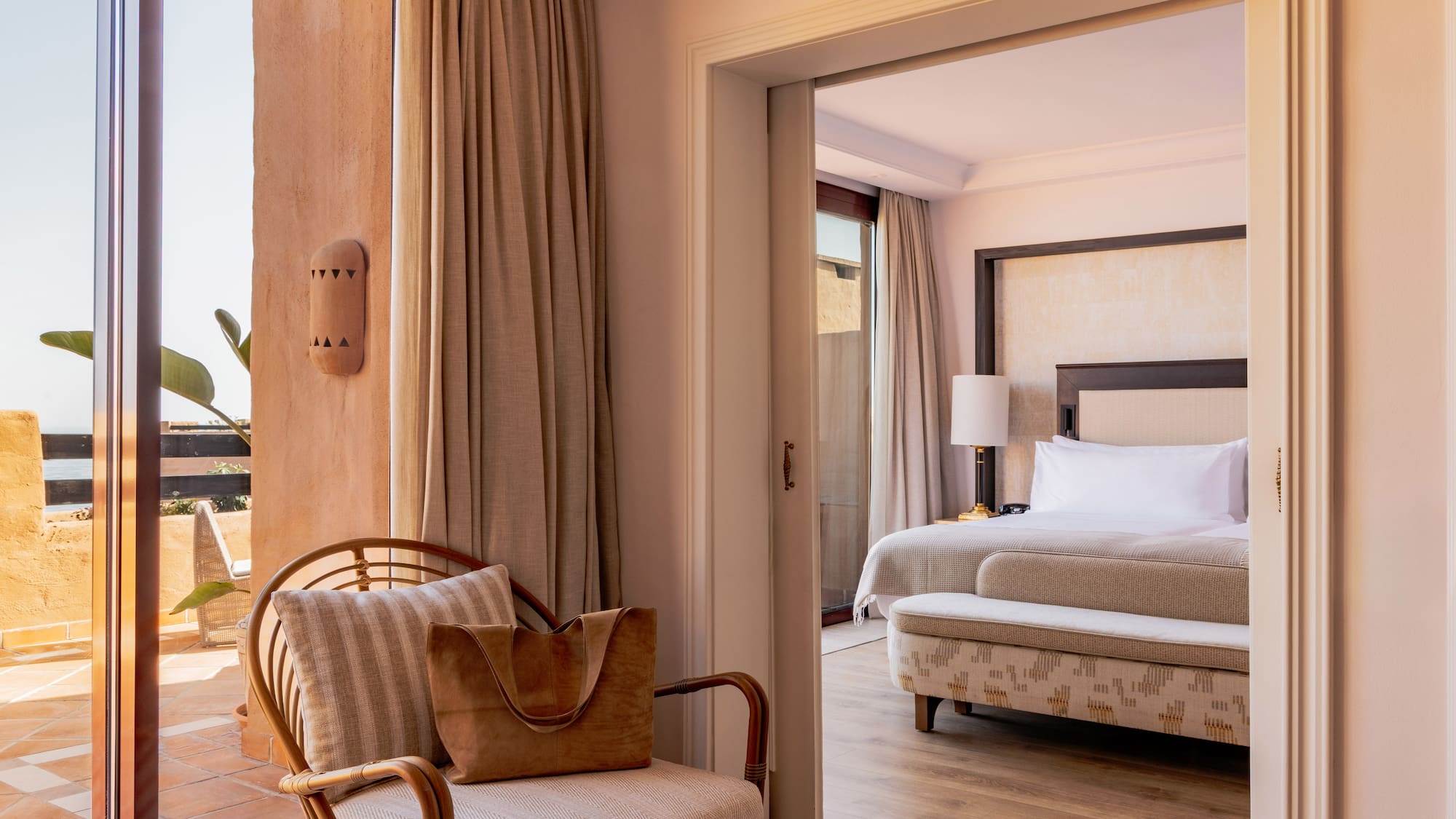 Elegant resort suite with private terrace access and spacious bedroom.