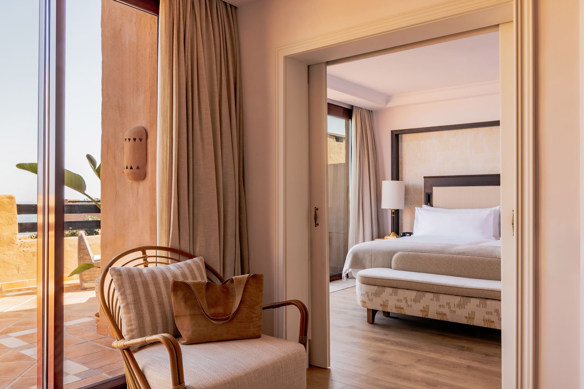 Elegant resort suite with private terrace access and spacious bedroom.
