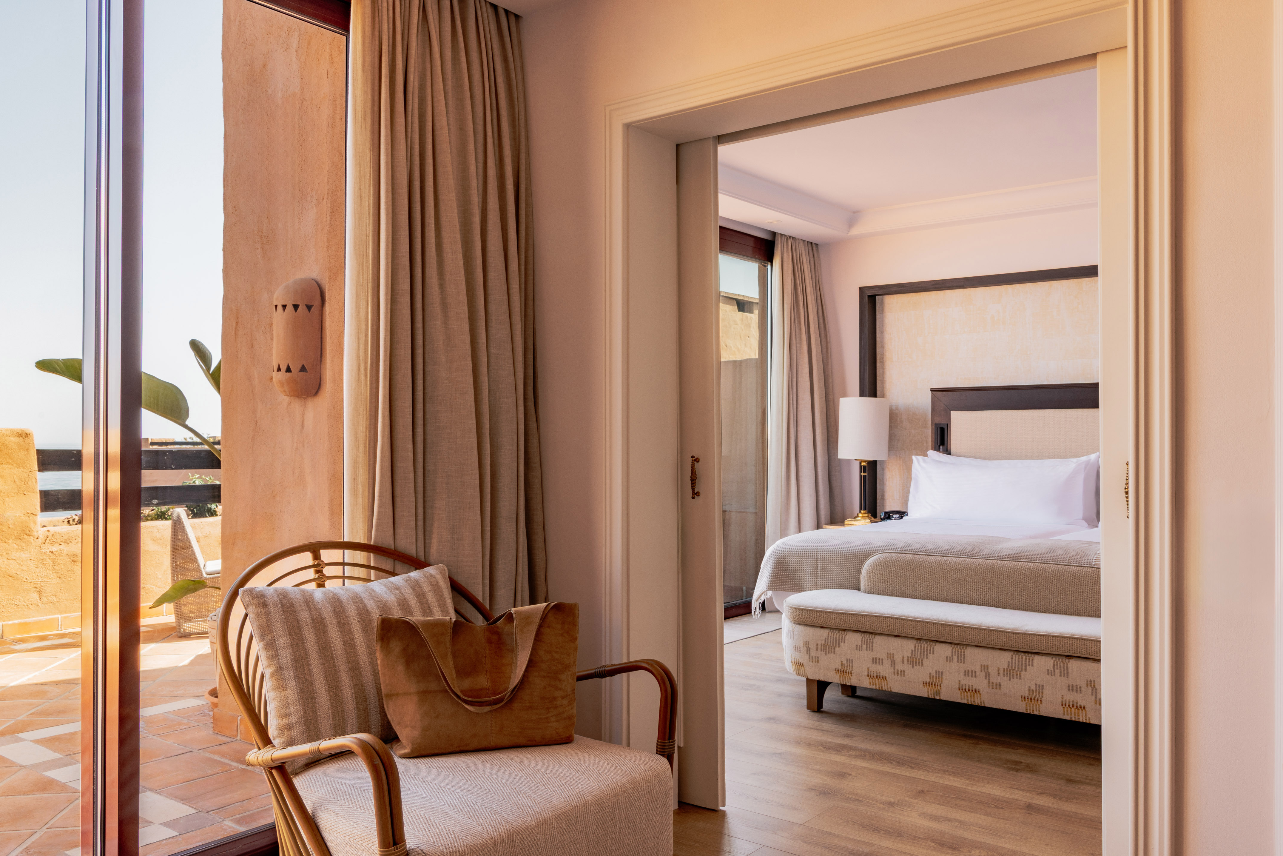 Elegant resort suite with private terrace access and spacious bedroom.