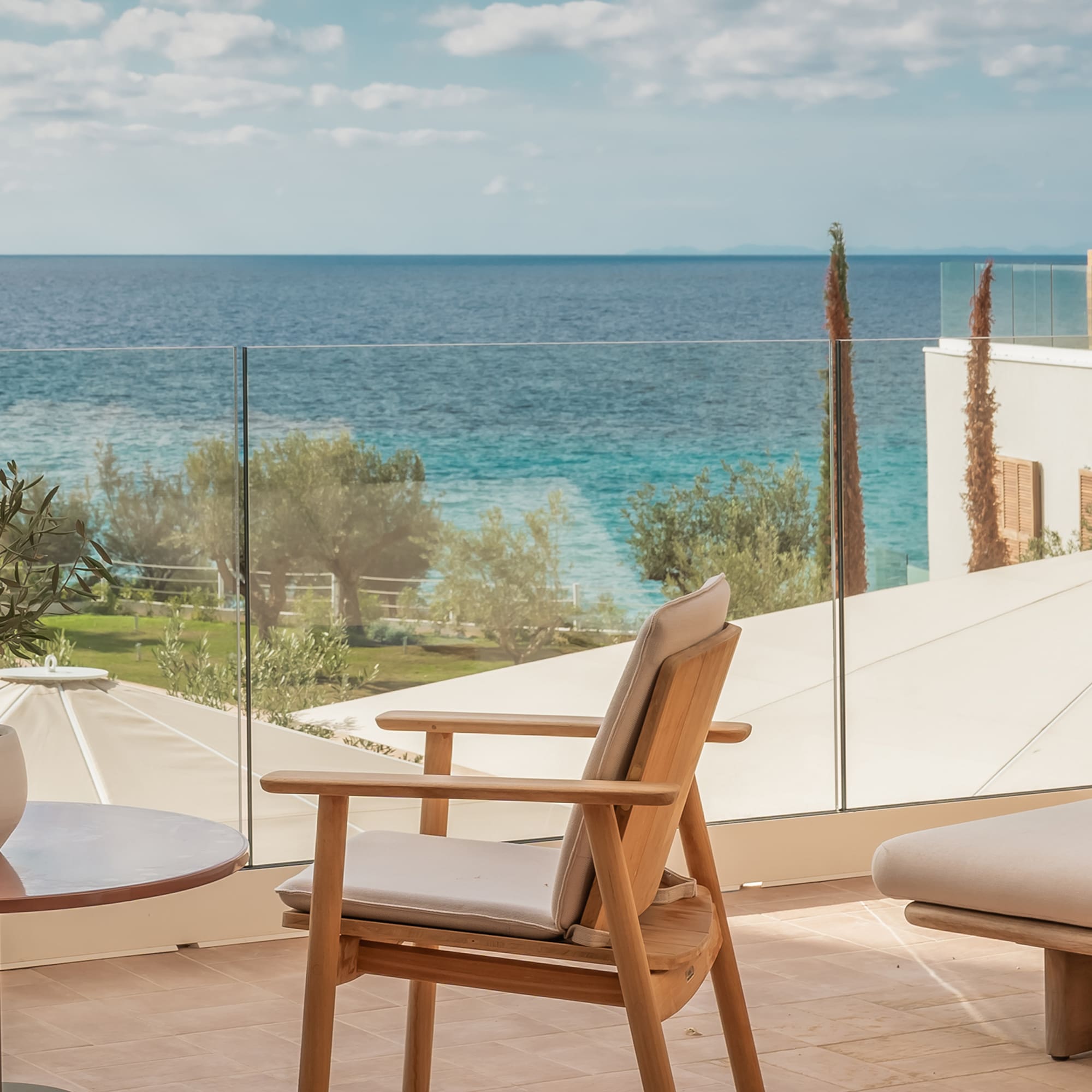 a chair and table on a balcony overlooking a body of water