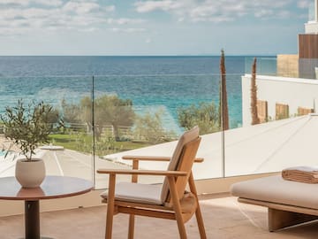 a chair and table with a view of the ocean