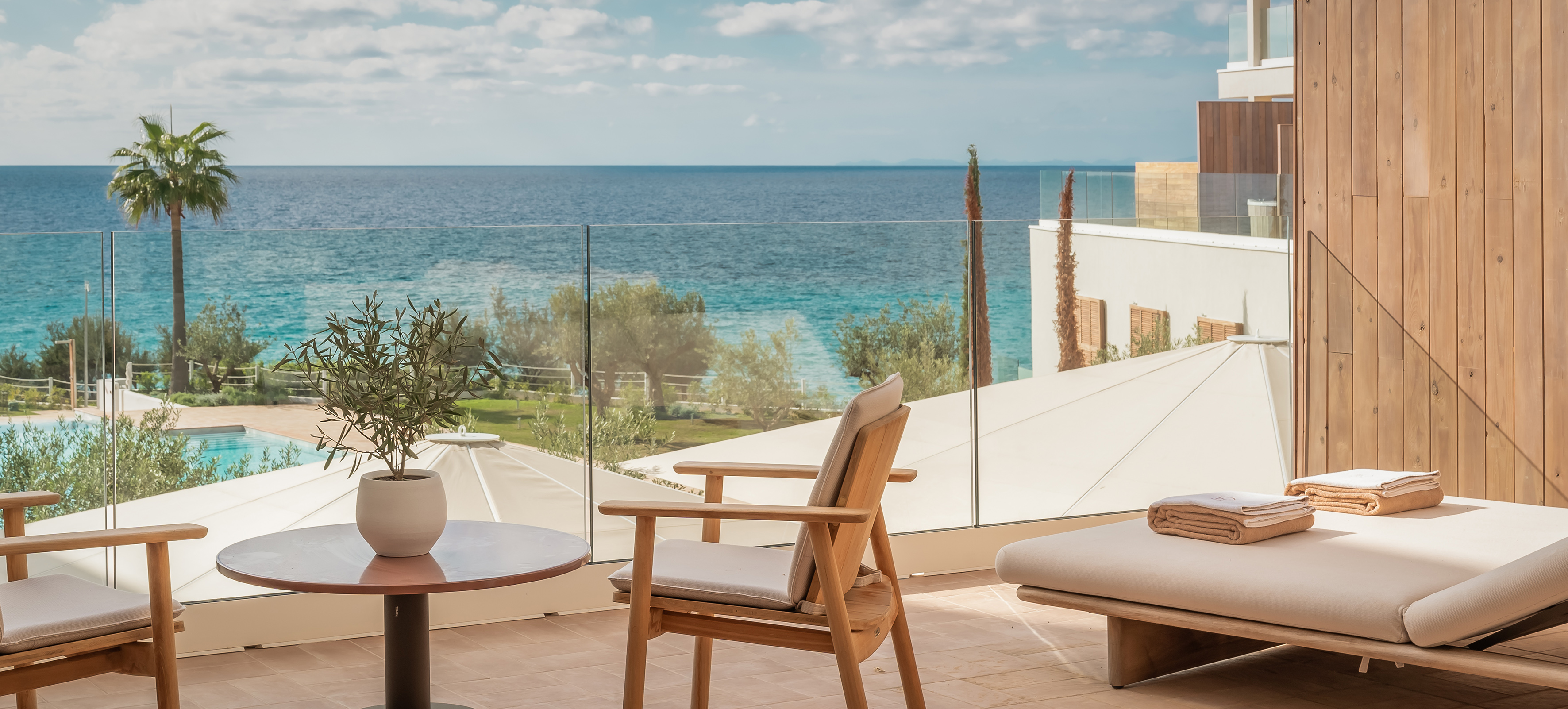 Oceanfront resort terrace with modern outdoor seating and turquoise sea.