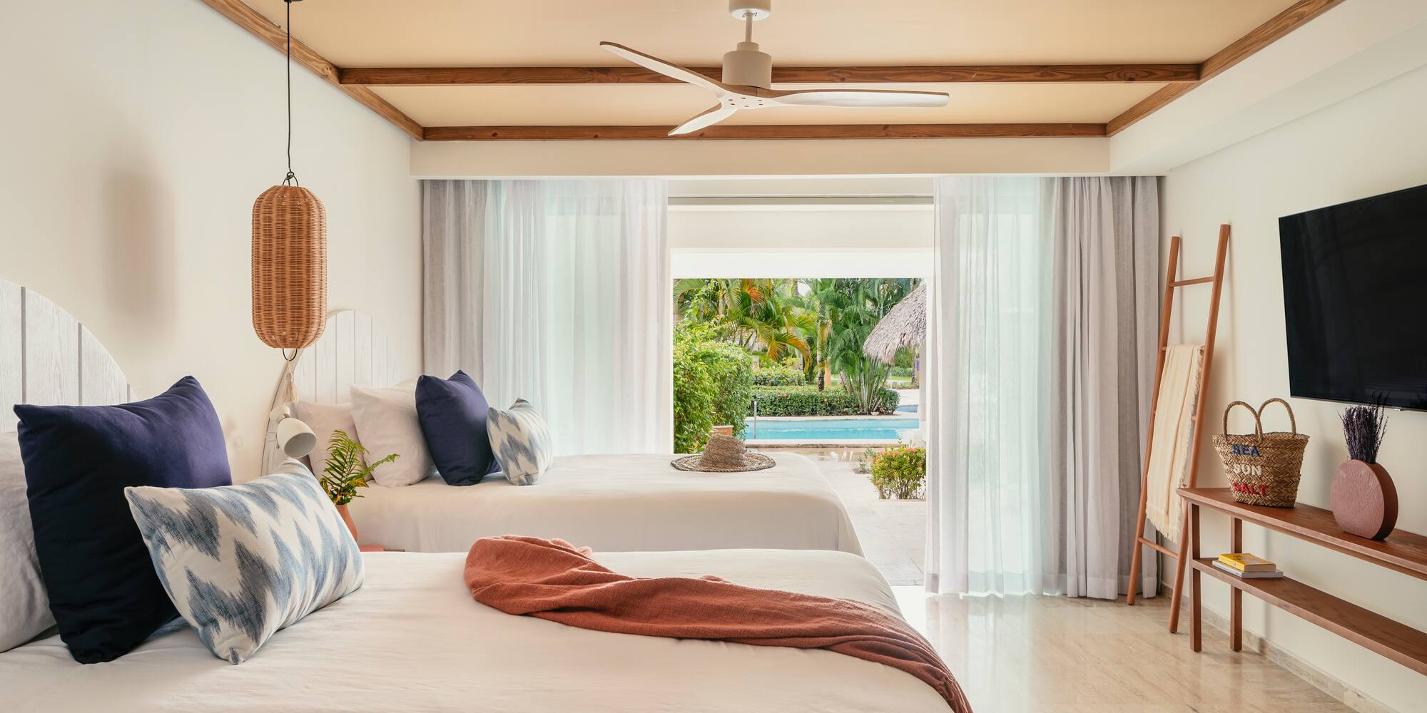 Tropical resort room with two beds and direct pool access.