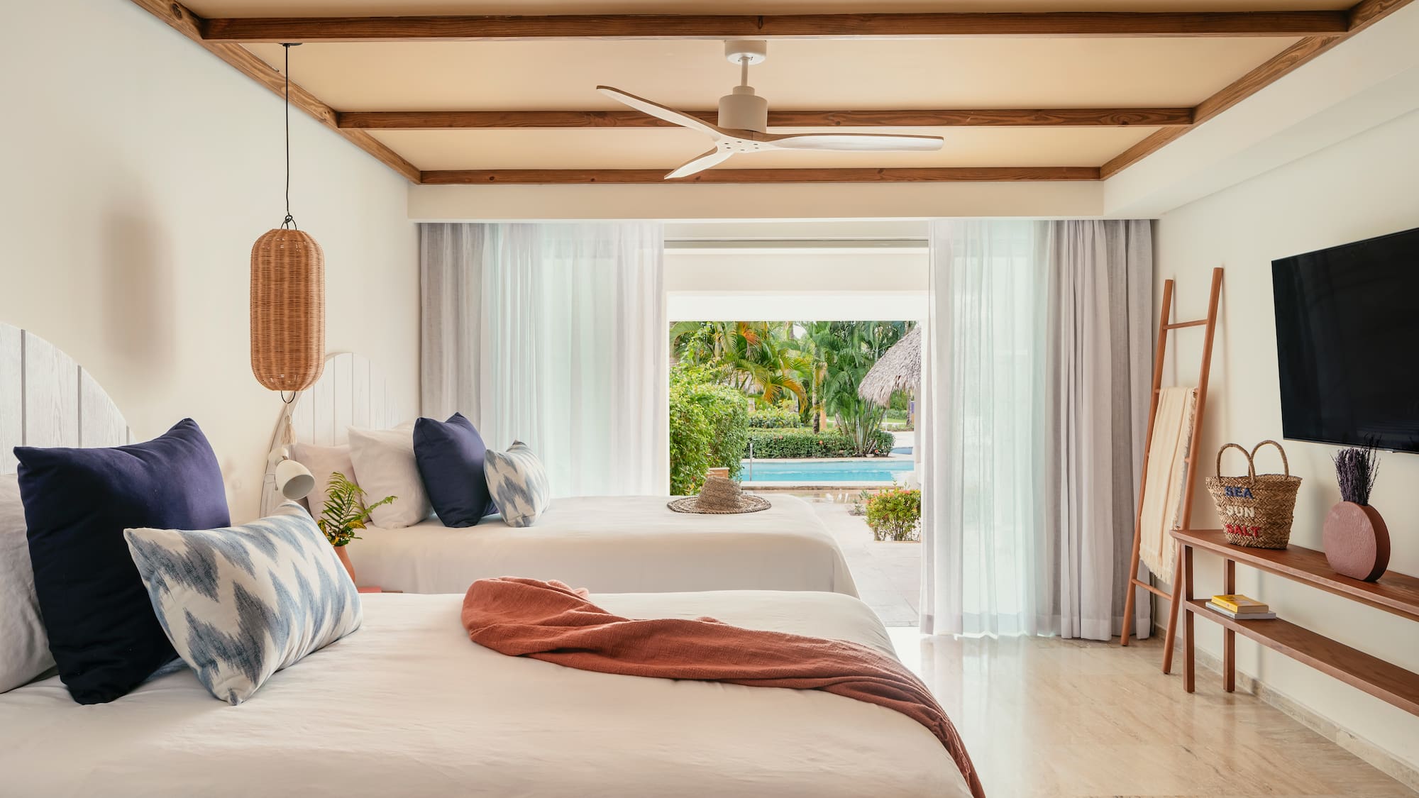 Tropical resort room with two beds and direct pool access.