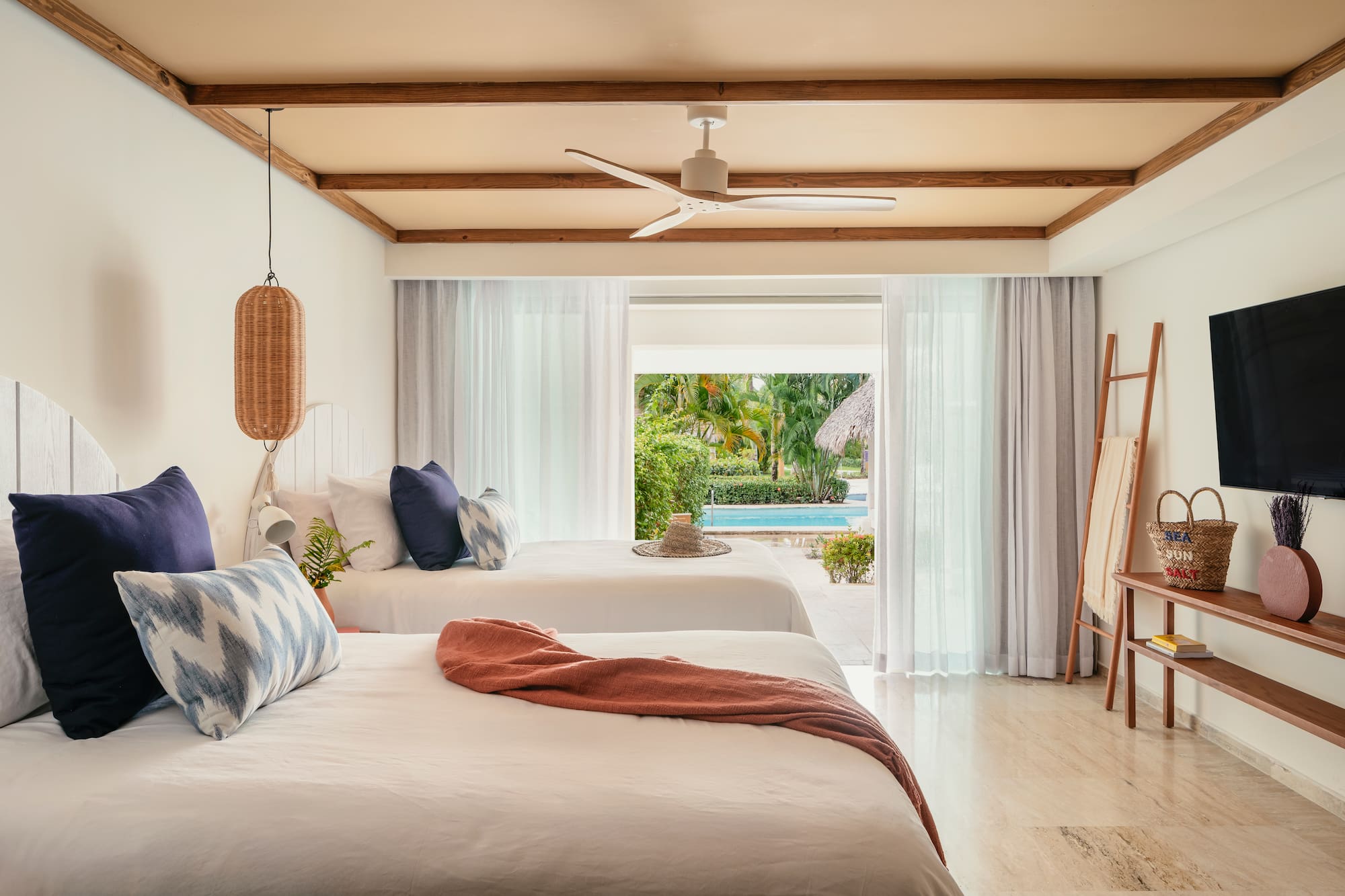Tropical resort room with two beds and direct pool access.