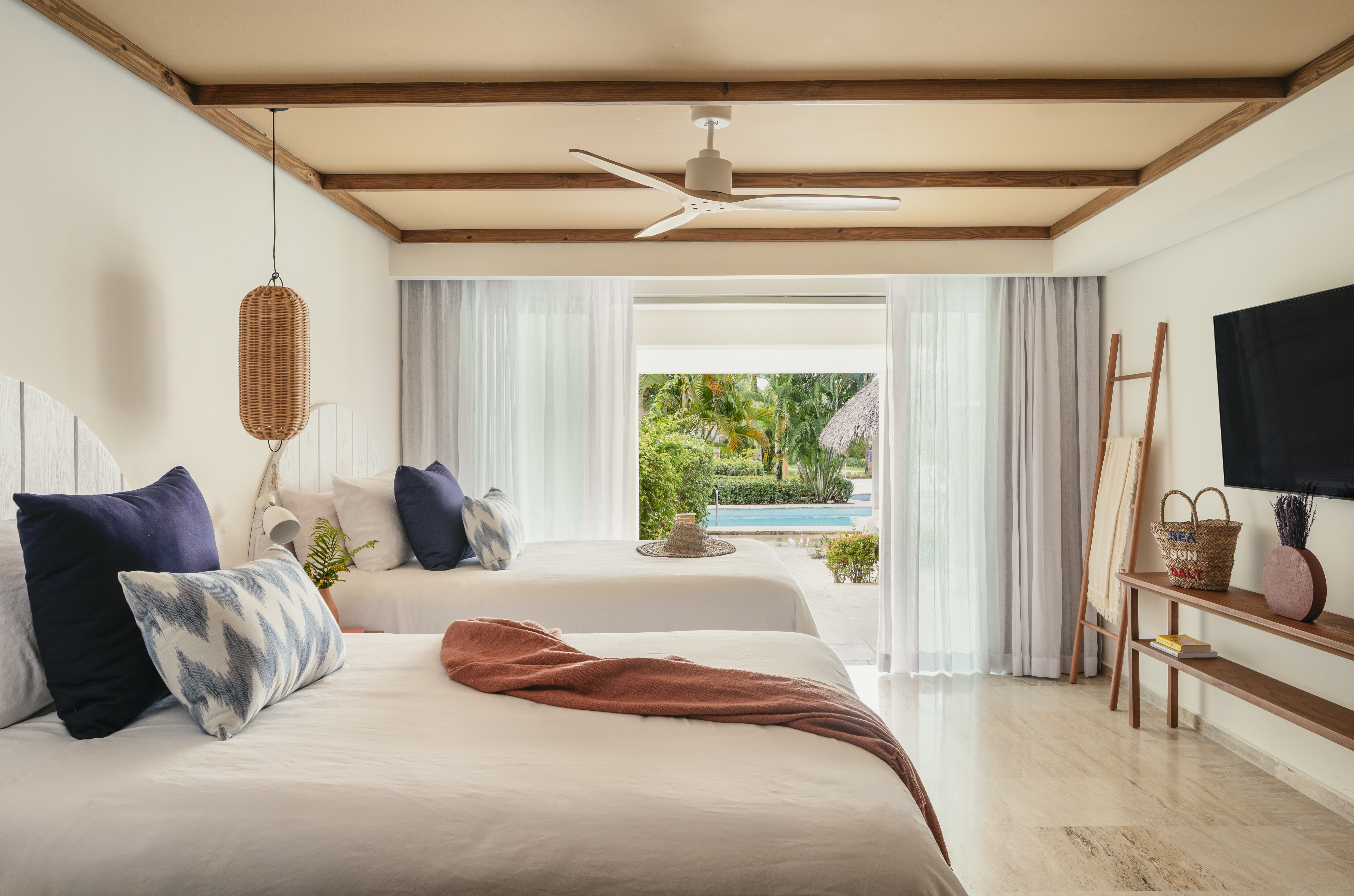 Tropical resort room with two beds and direct pool access.