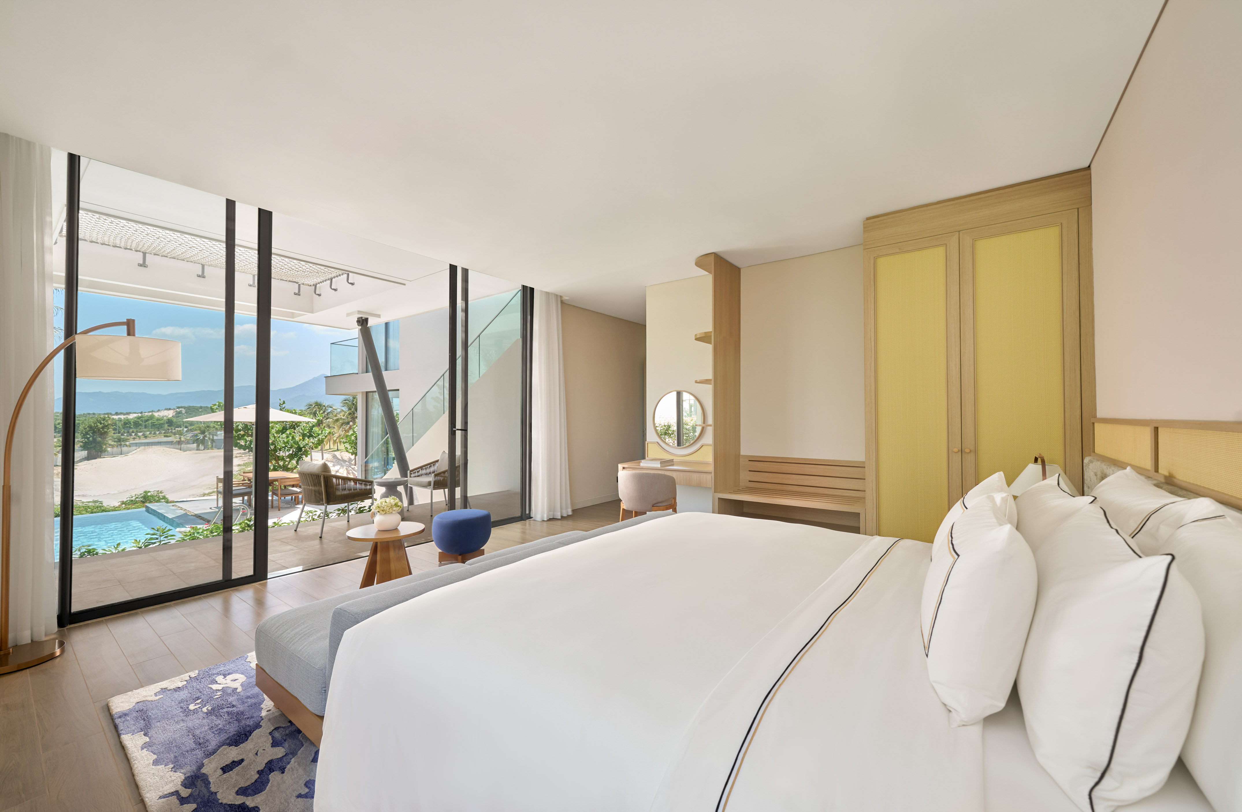 Luxury resort bedroom with private pool patio and mountain views.