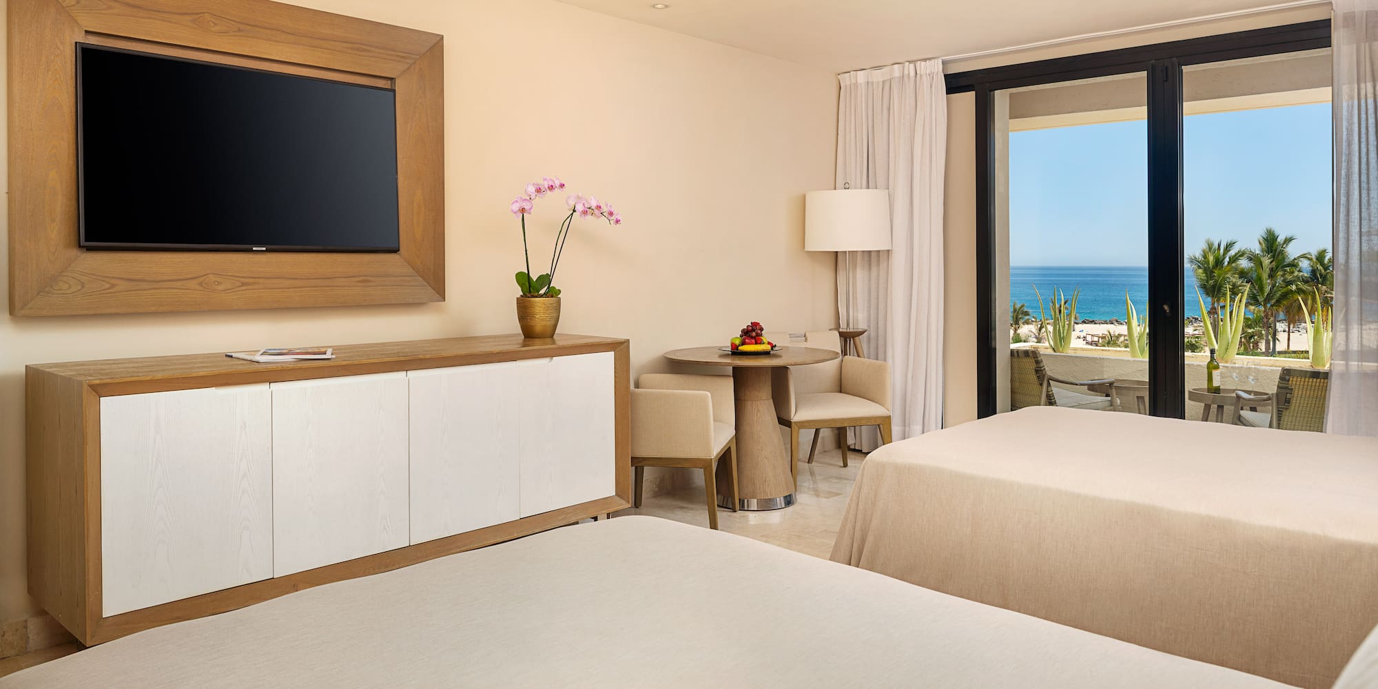 a room with two beds and a television on the wall