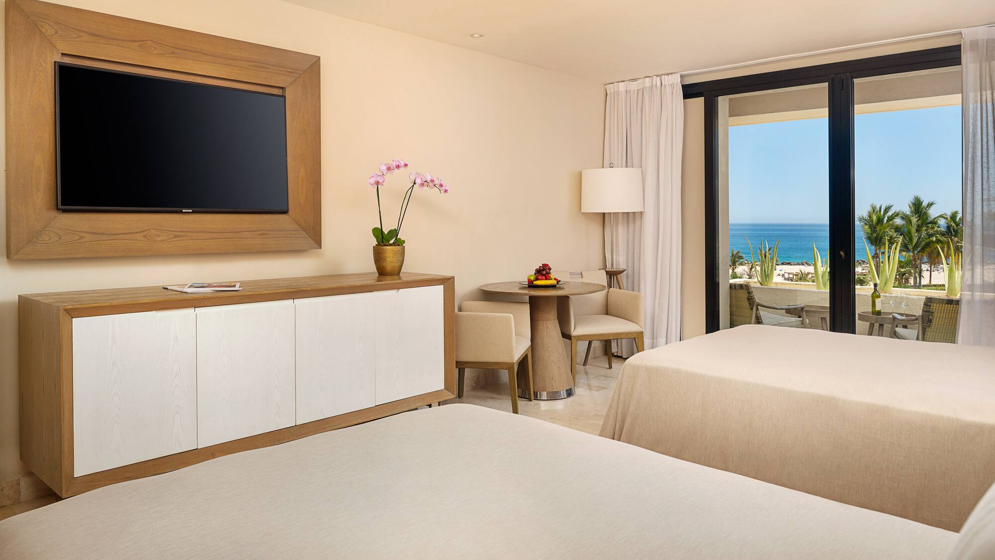 a room with two beds and a television on the wall