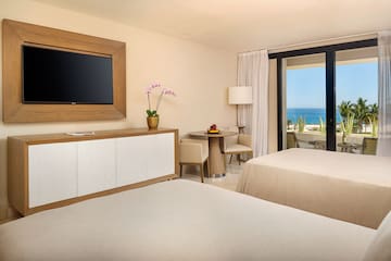 a room with two beds and a television on the wall