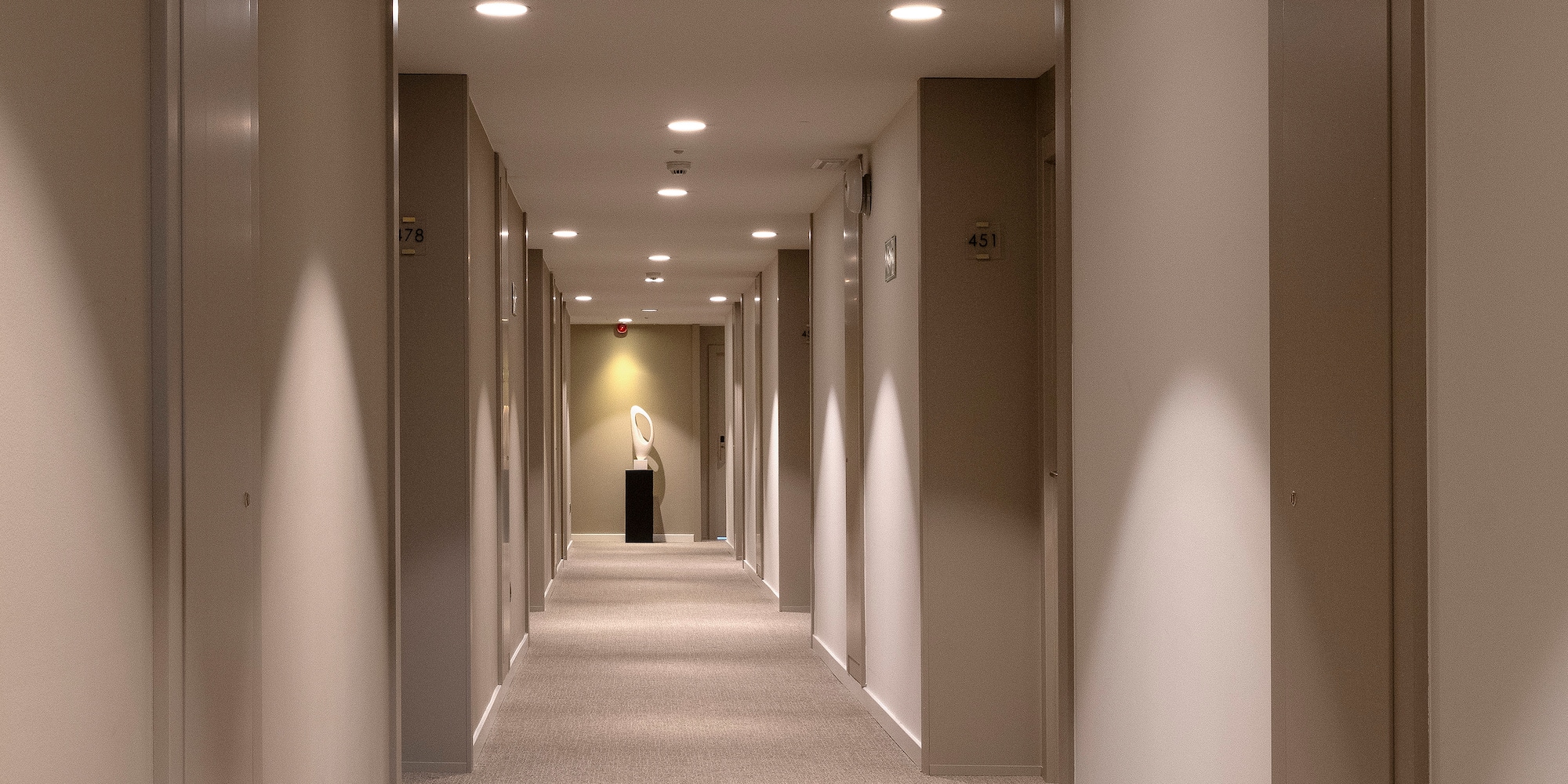 a hallway with a statue on the side
