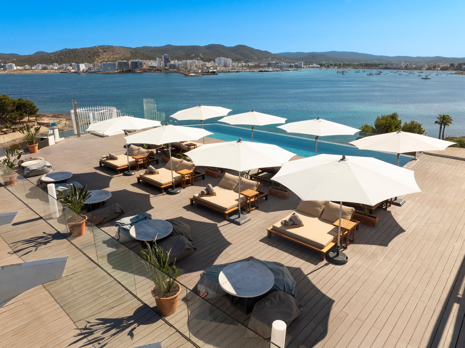 a group of chairs and umbrellas on a deck overlooking a body of water