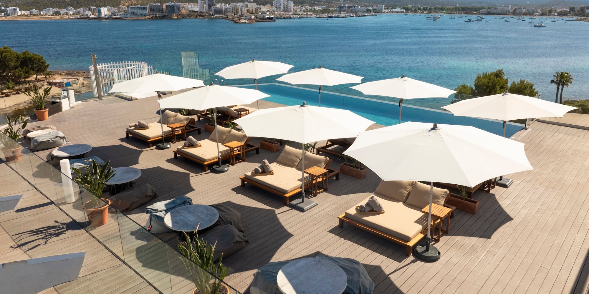 a group of chairs and umbrellas on a deck overlooking a body of water