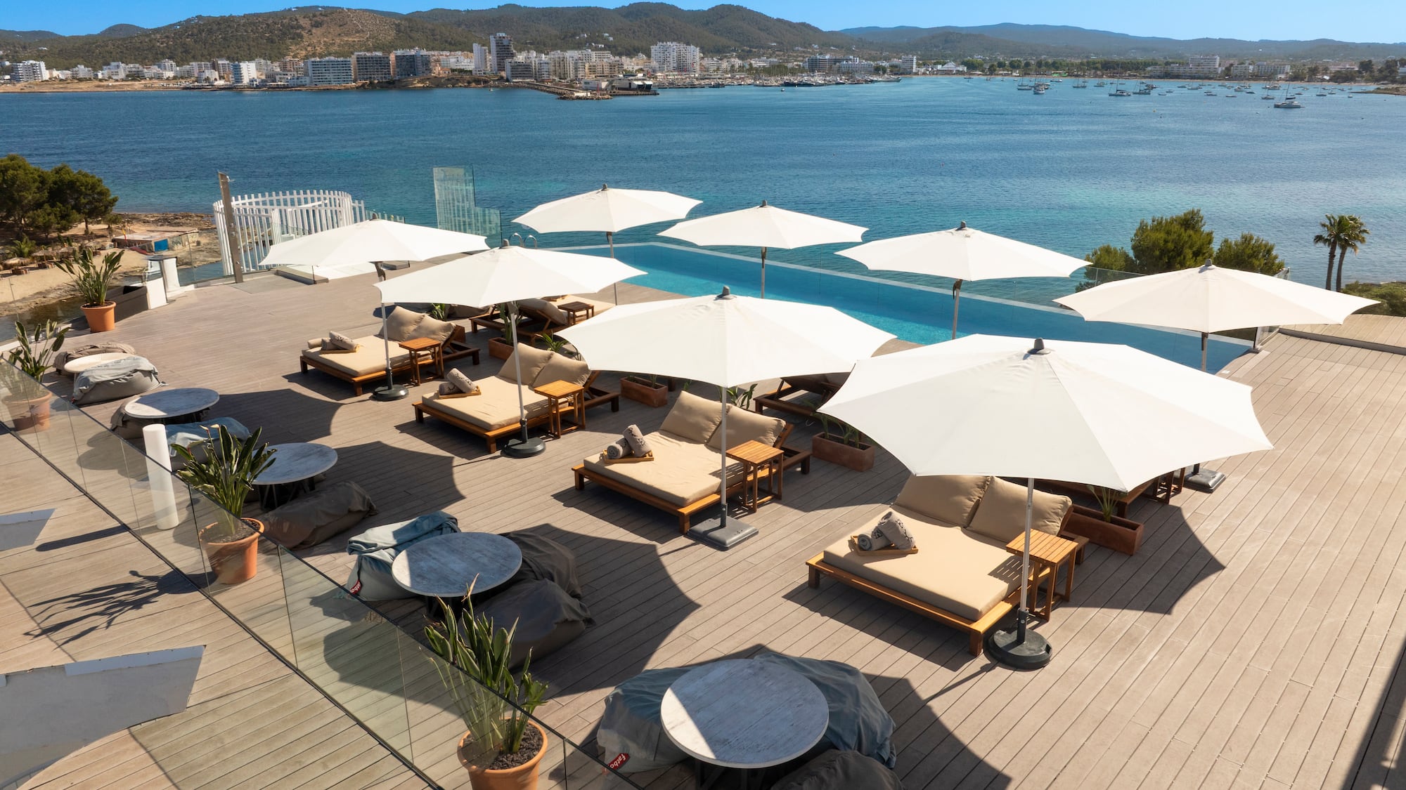 a group of chairs and umbrellas on a deck overlooking a body of water