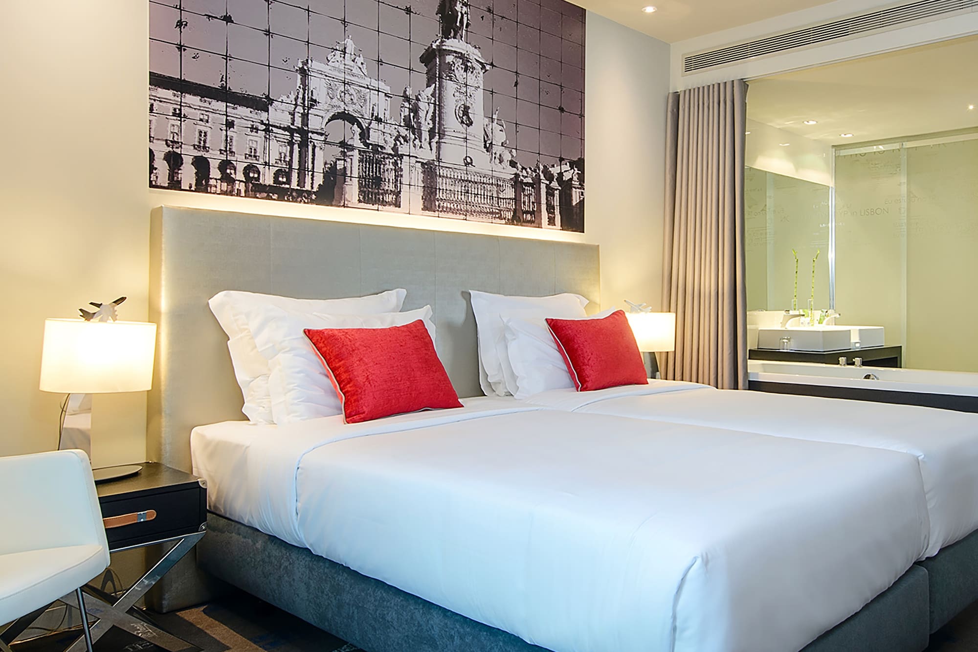 a bed with red pillows and a picture on the wall