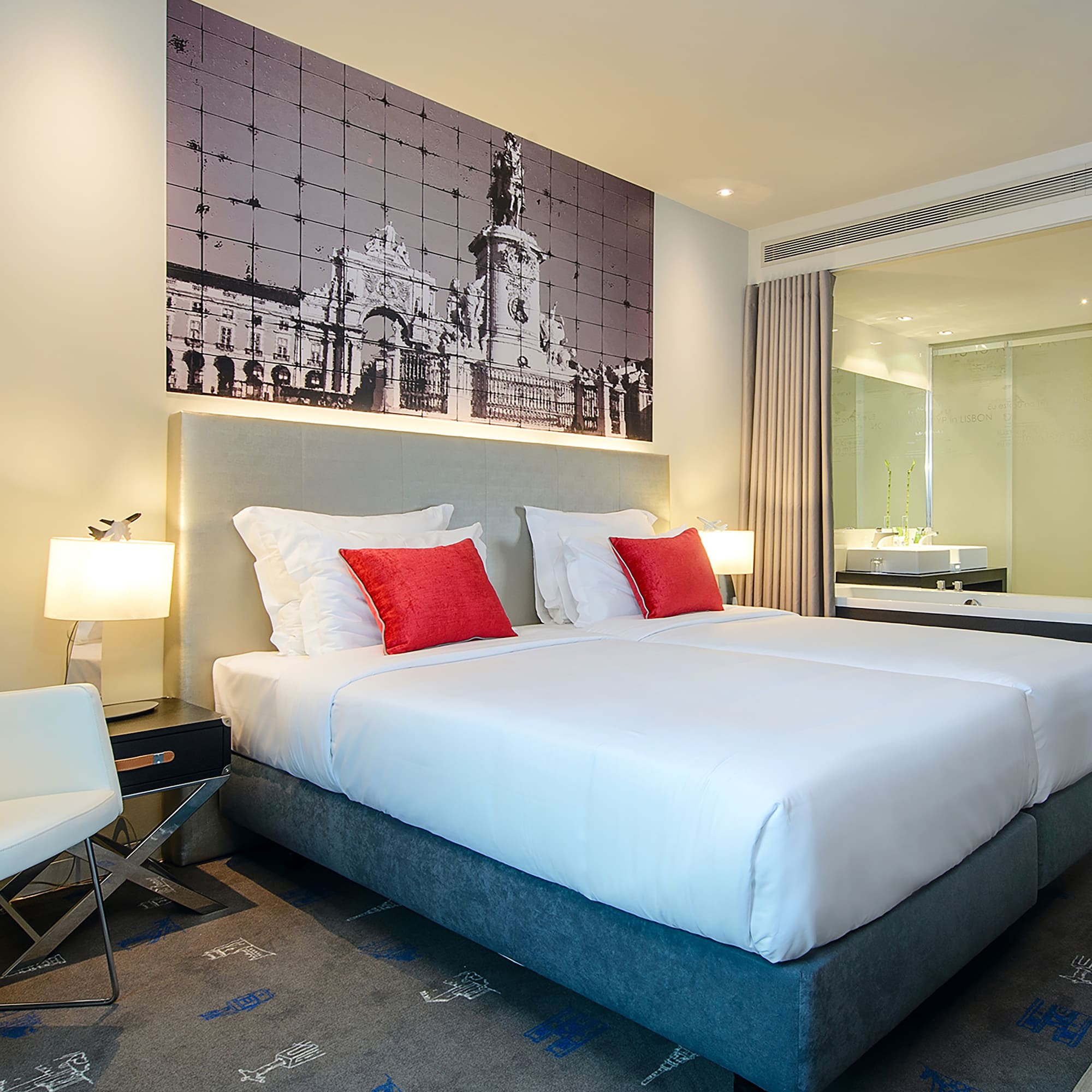 a bed with red pillows and a picture on the wall