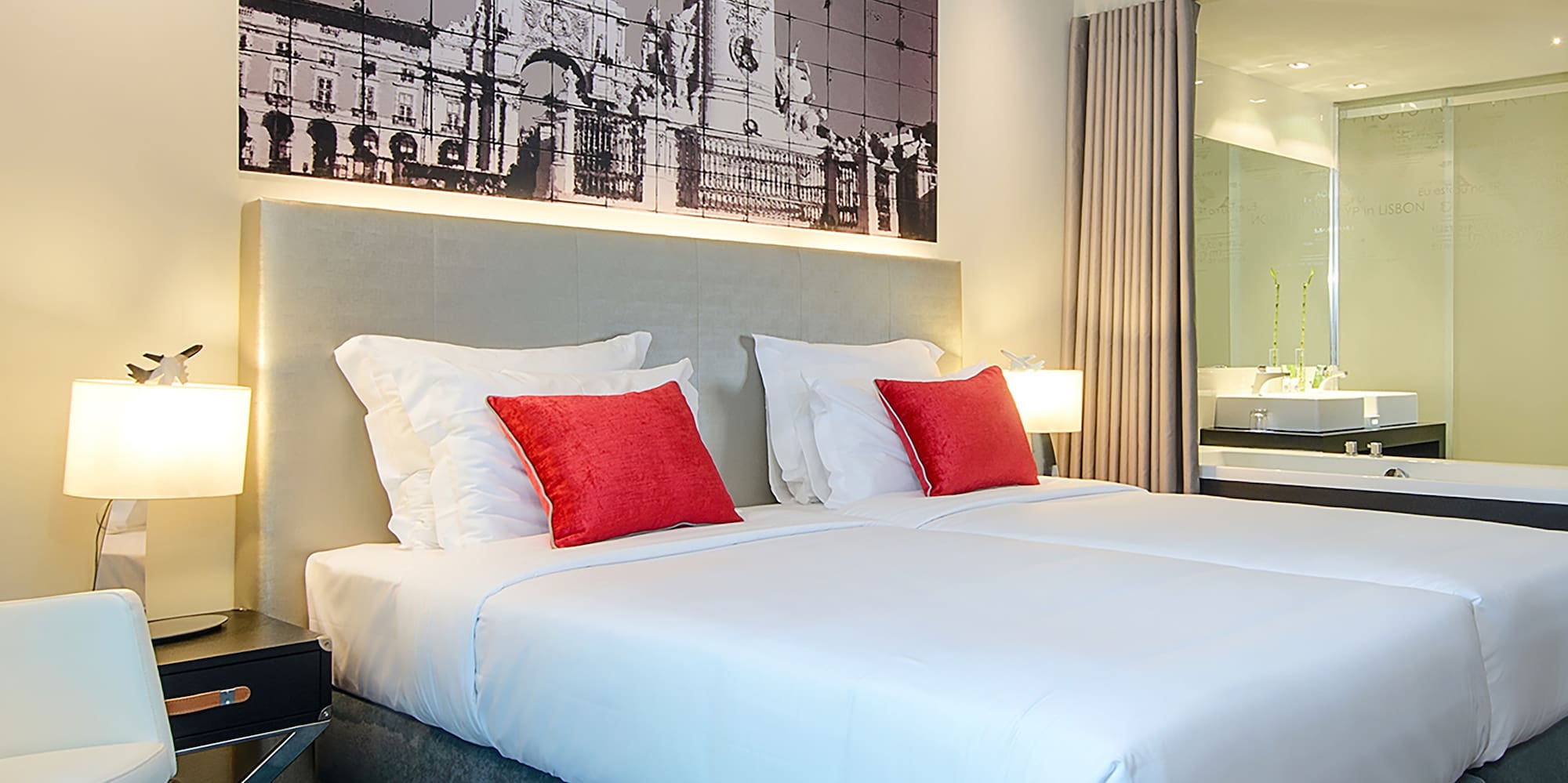 a bed with red pillows and a picture on the wall