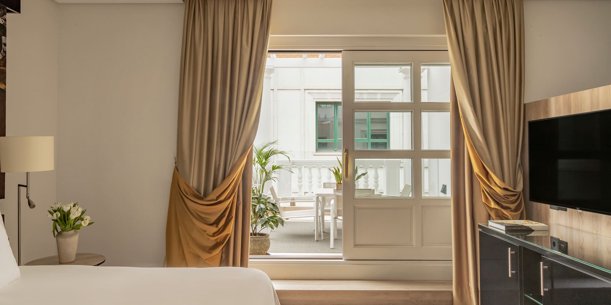a bedroom with a bed and a piano and a glass door