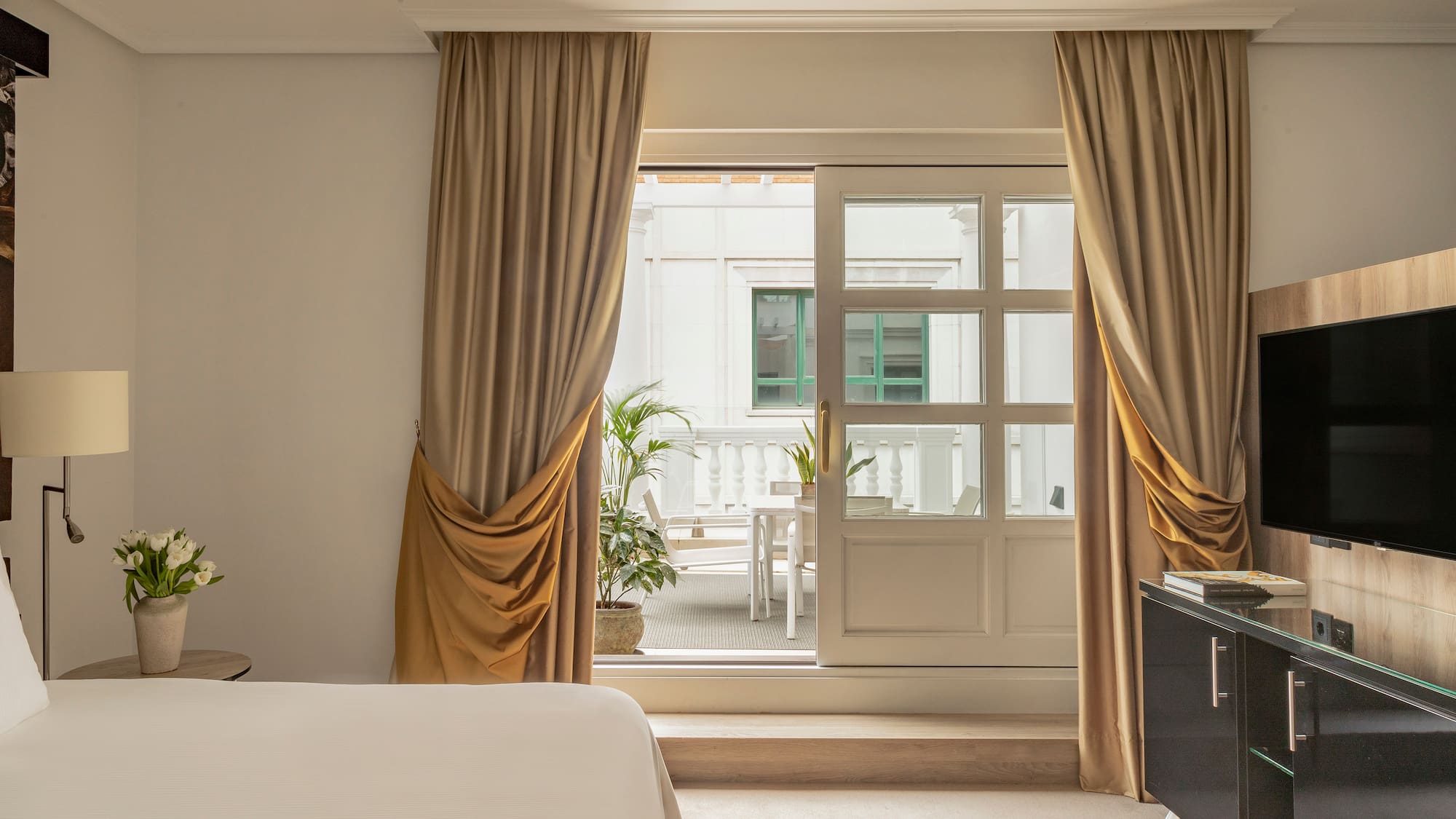 a bedroom with a bed and a piano and a glass door