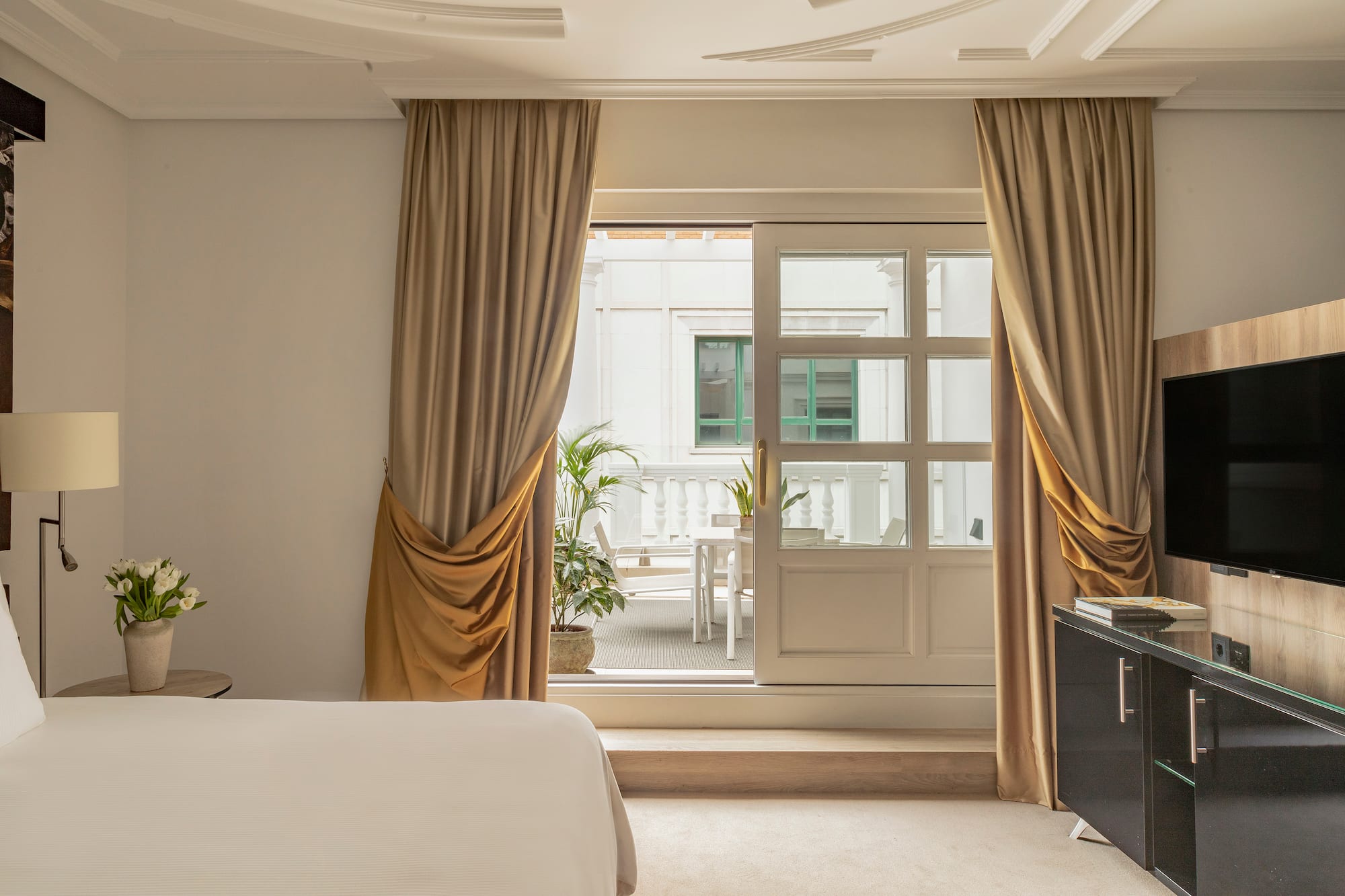 a bedroom with a bed and a piano and a glass door
