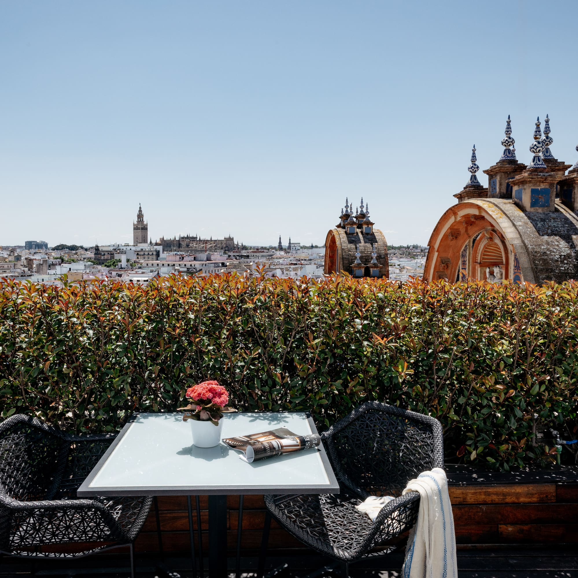 a table and chairs on a rooftop overlooking a city
