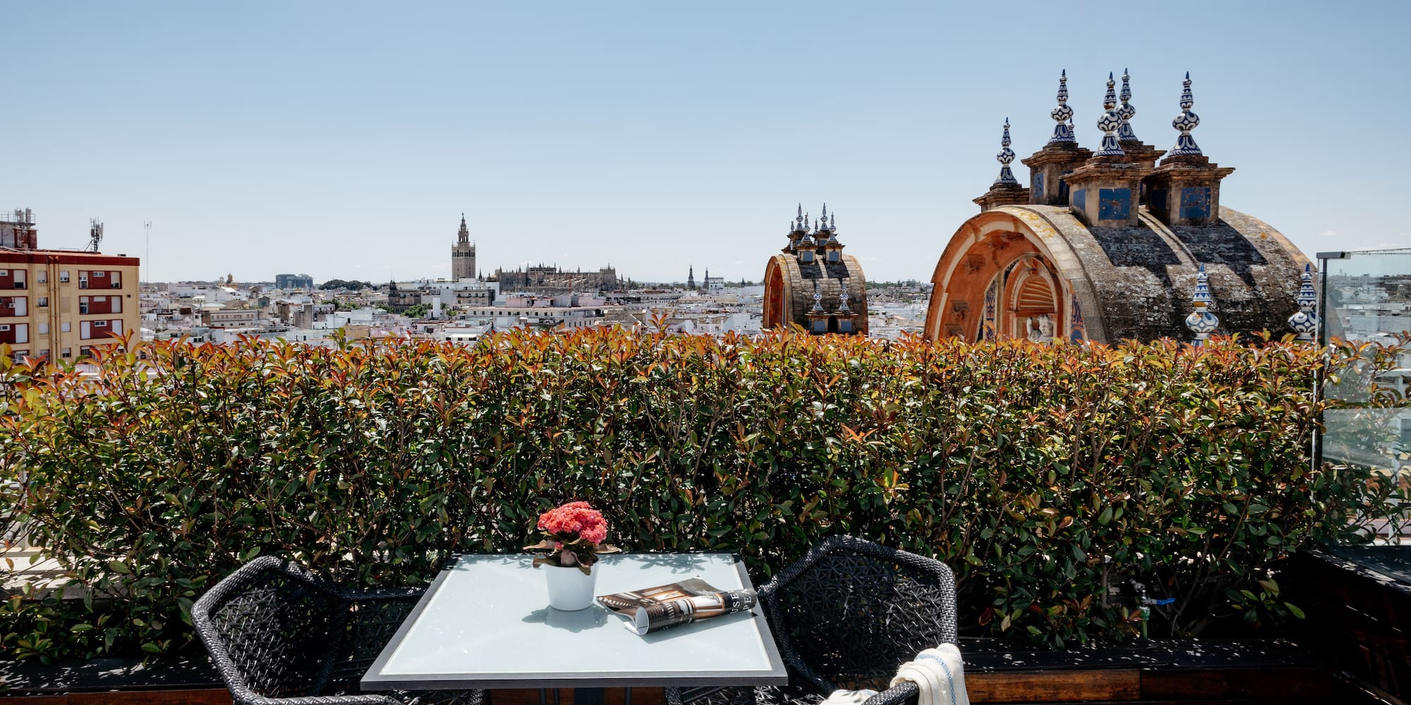 a table and chairs on a rooftop overlooking a city