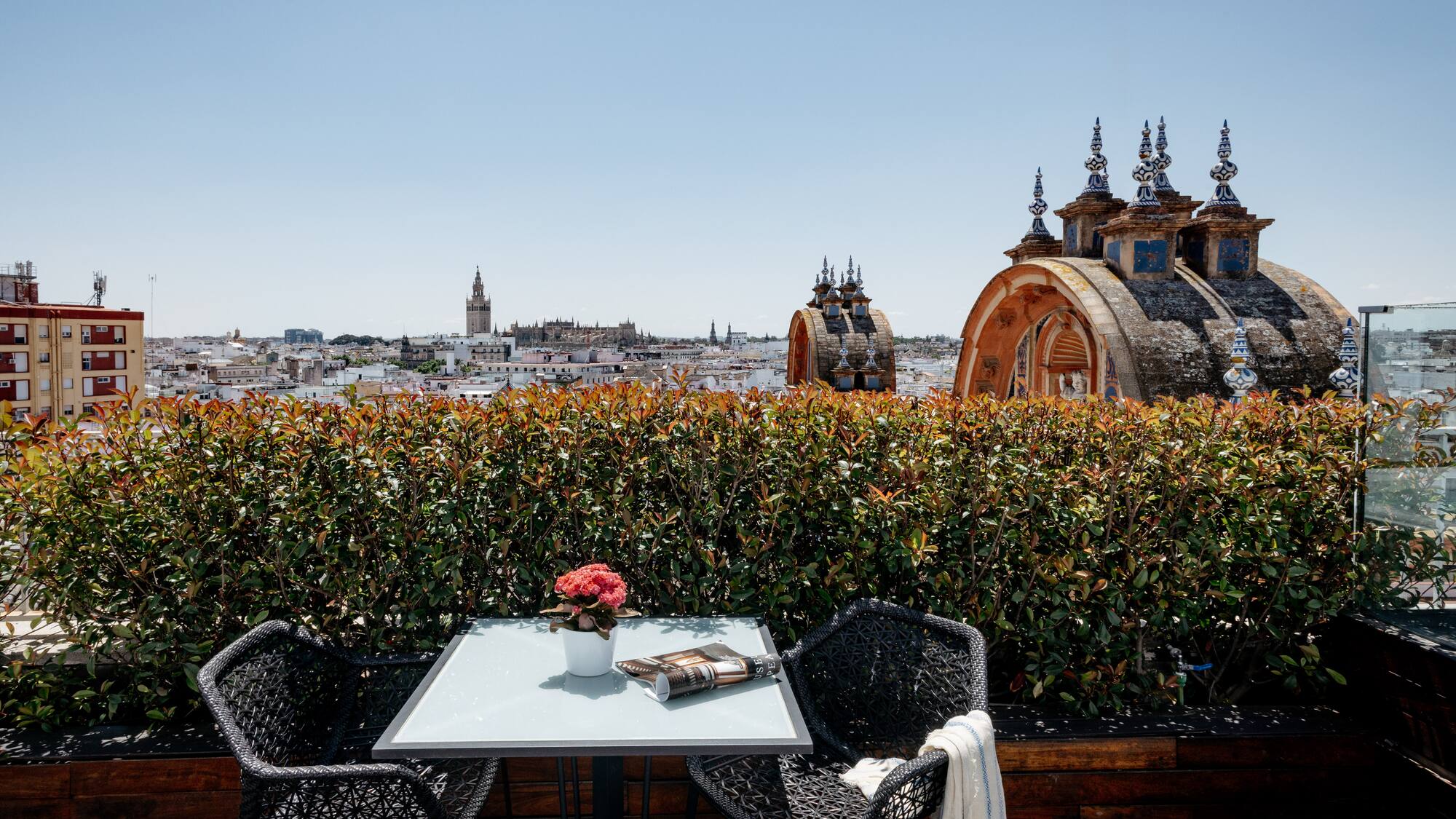 a table and chairs on a rooftop overlooking a city