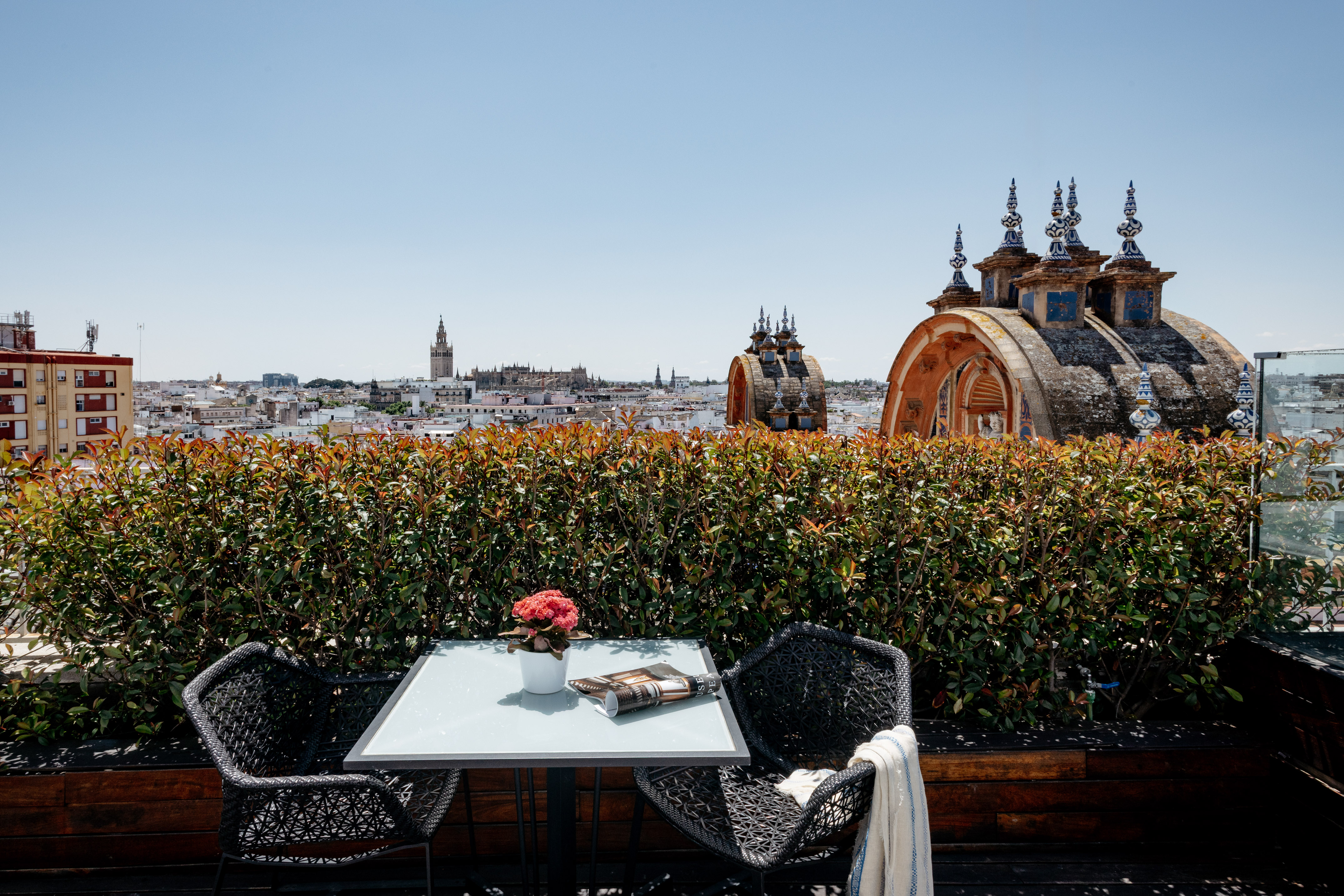 a table and chairs on a rooftop overlooking a city