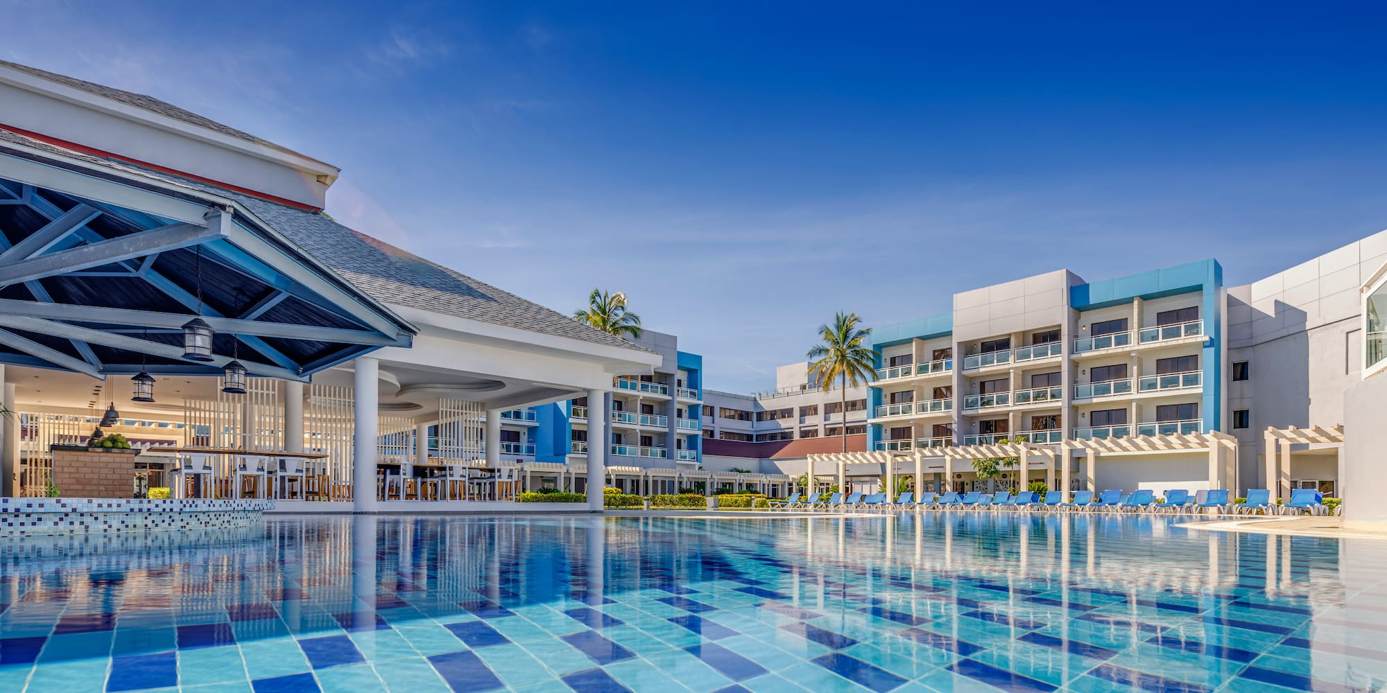 a pool with chairs and a building in the background