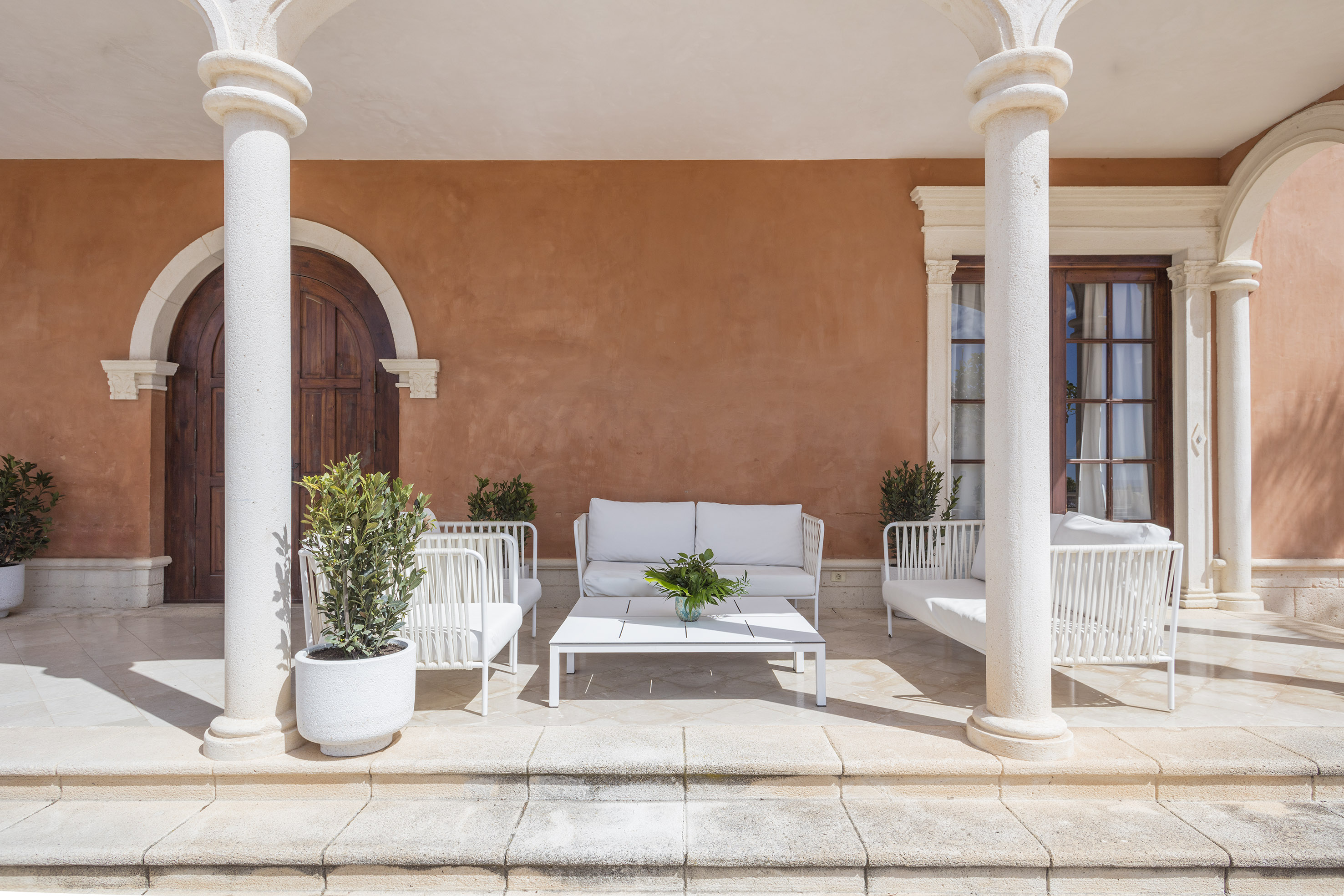 a white couches and chairs outside of a building