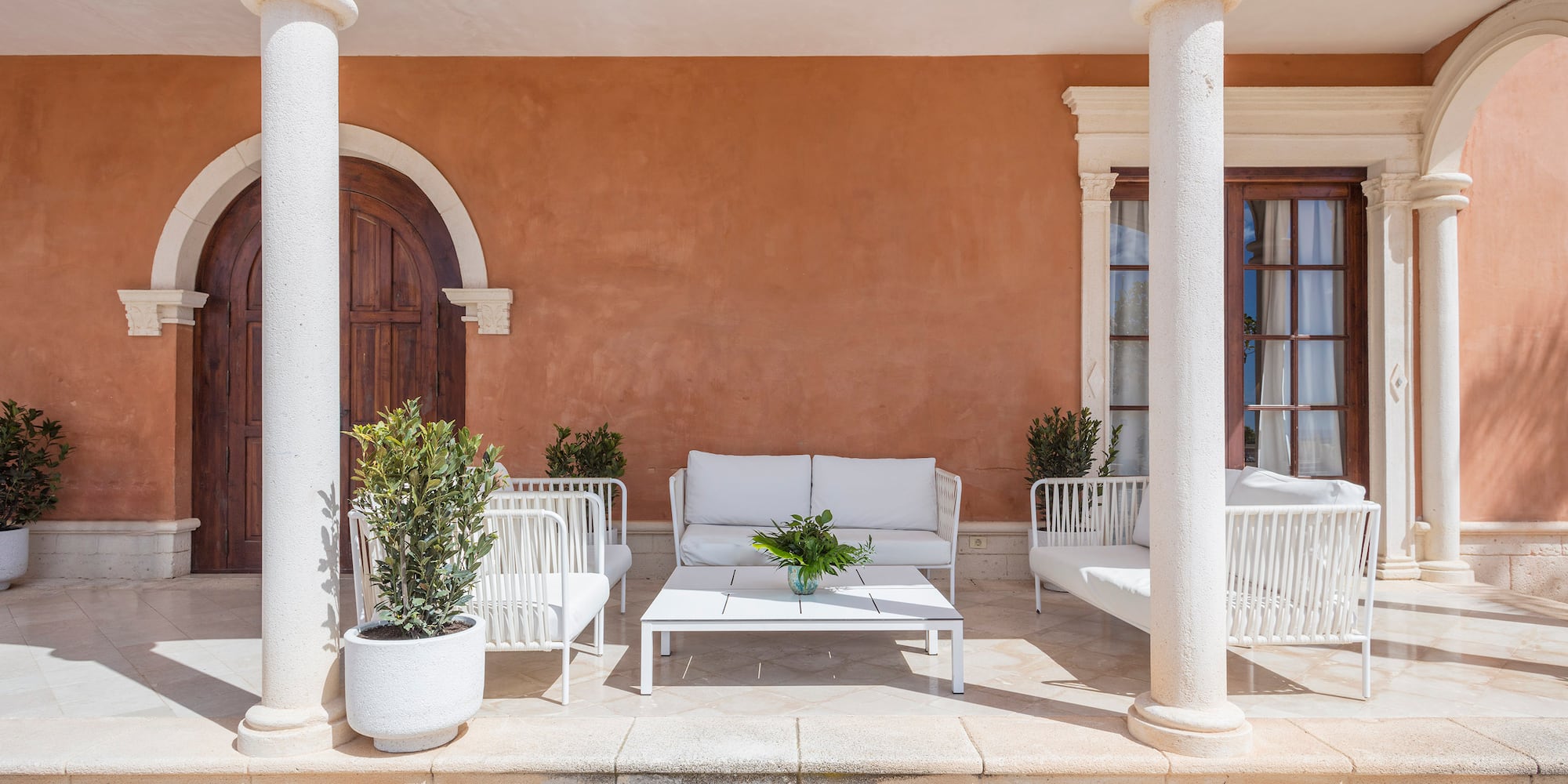 a white couches and chairs outside of a building