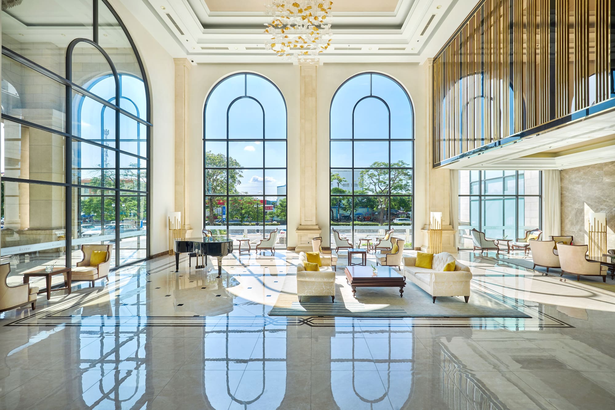 Luxury hotel lobby, arched windows, polished marble, elegant seating.