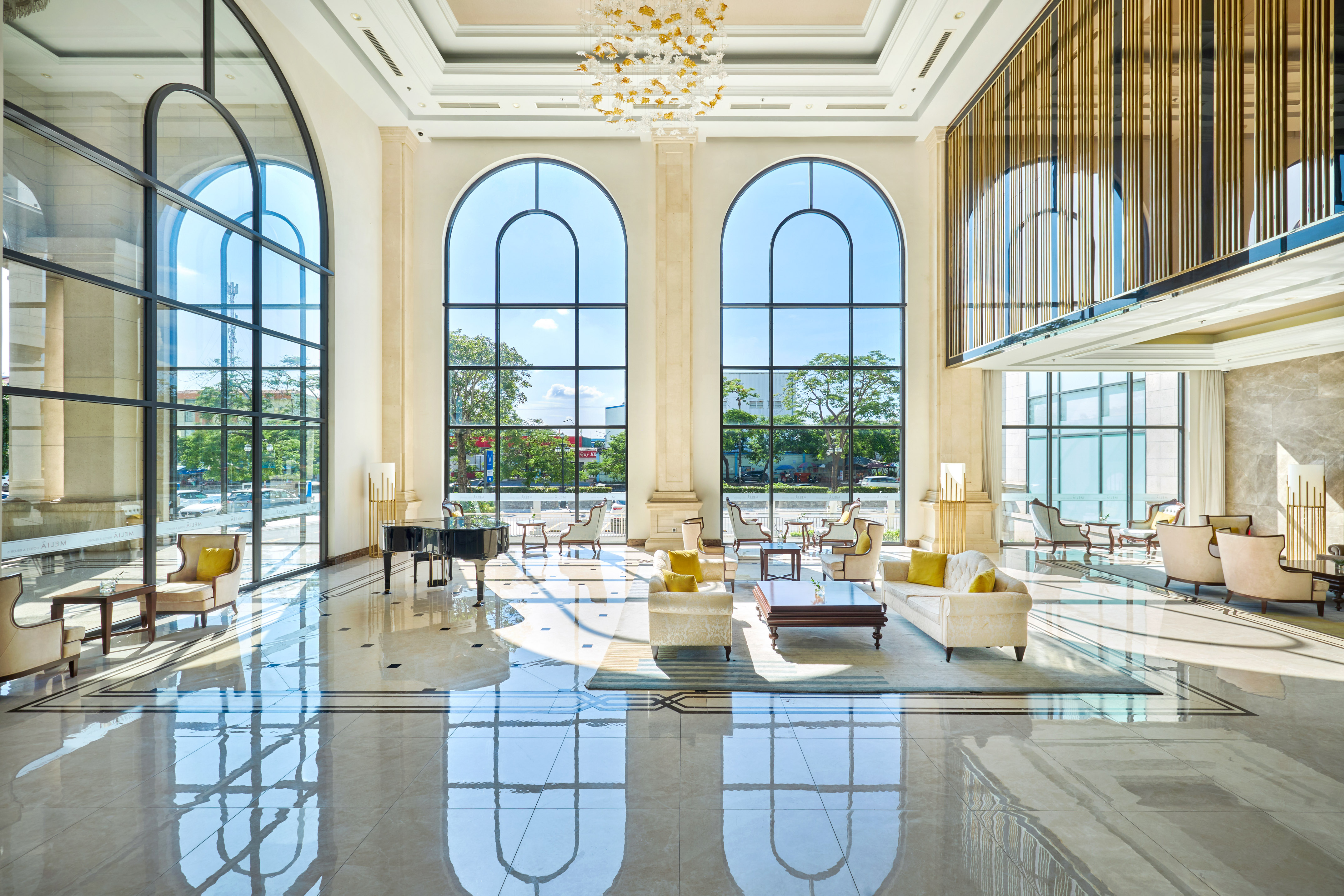 Luxury hotel lobby, arched windows, polished marble, elegant seating.