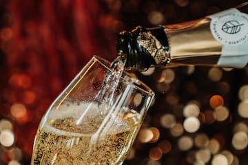 a person pouring champagne into a glass