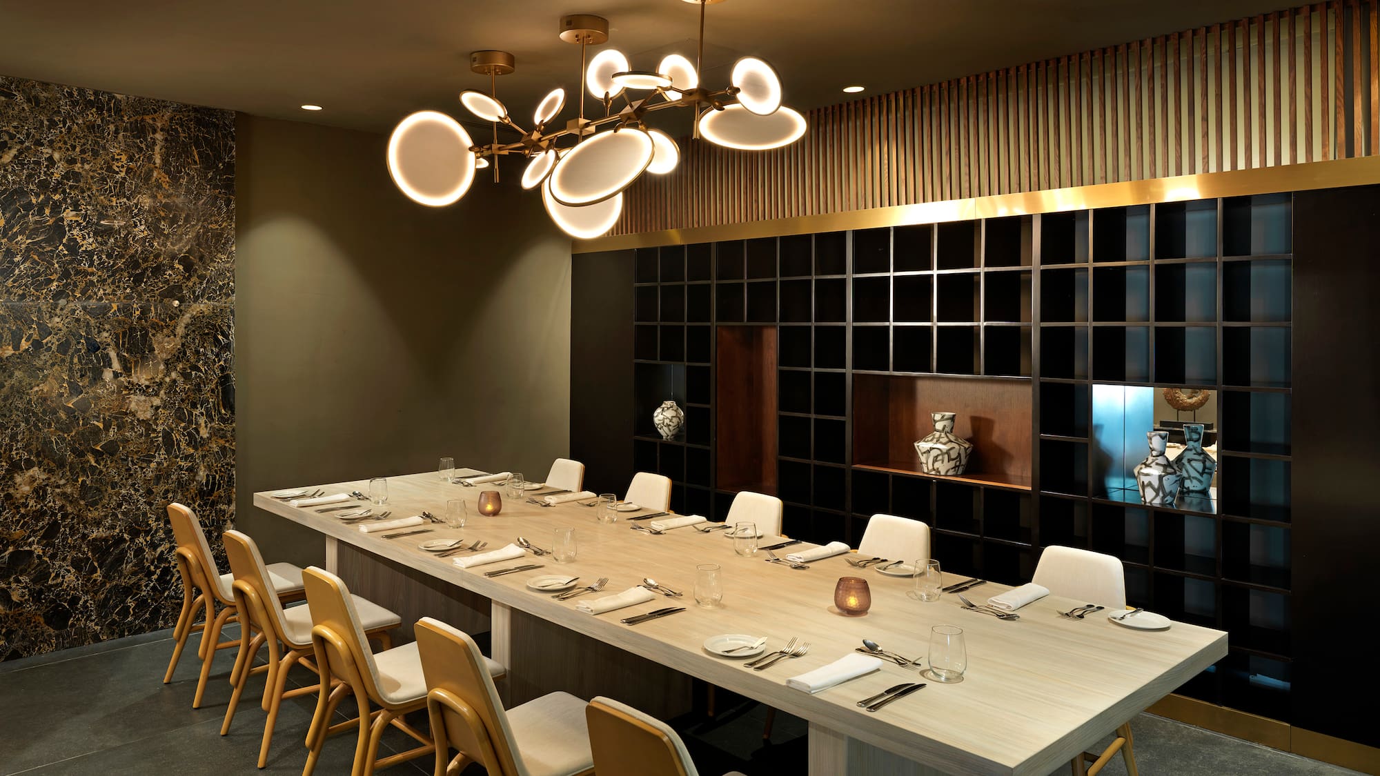 a long table with chairs and a chandelier