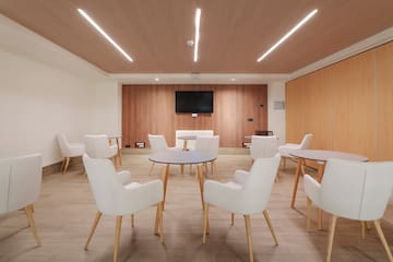 a room with white chairs and a tv