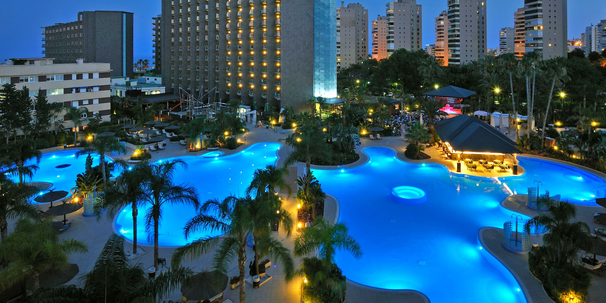 a pool with lights in the background