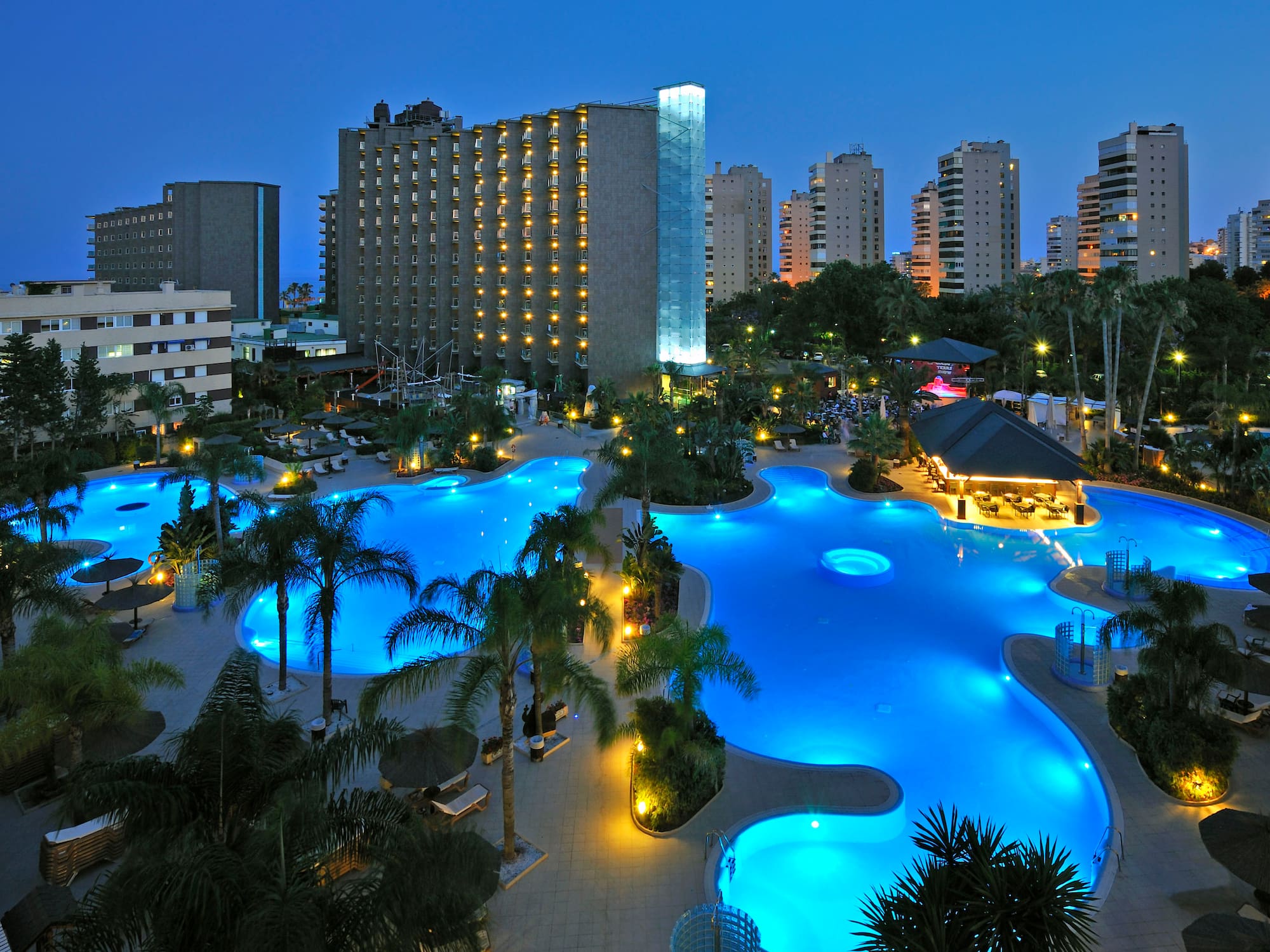 a pool with lights in the background